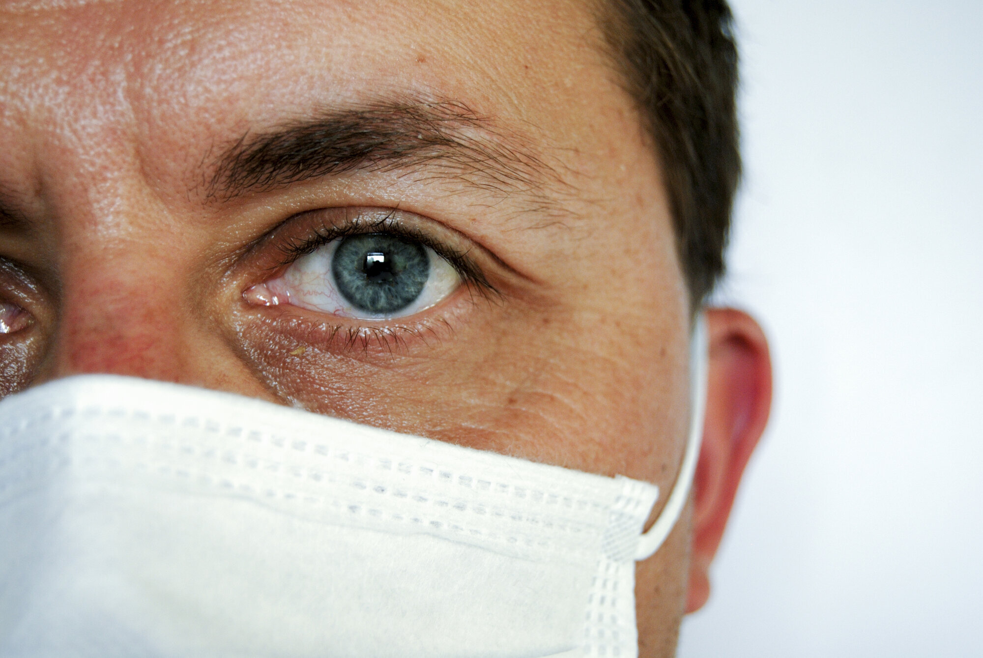 Bildet viser et ansikt med munnbind.