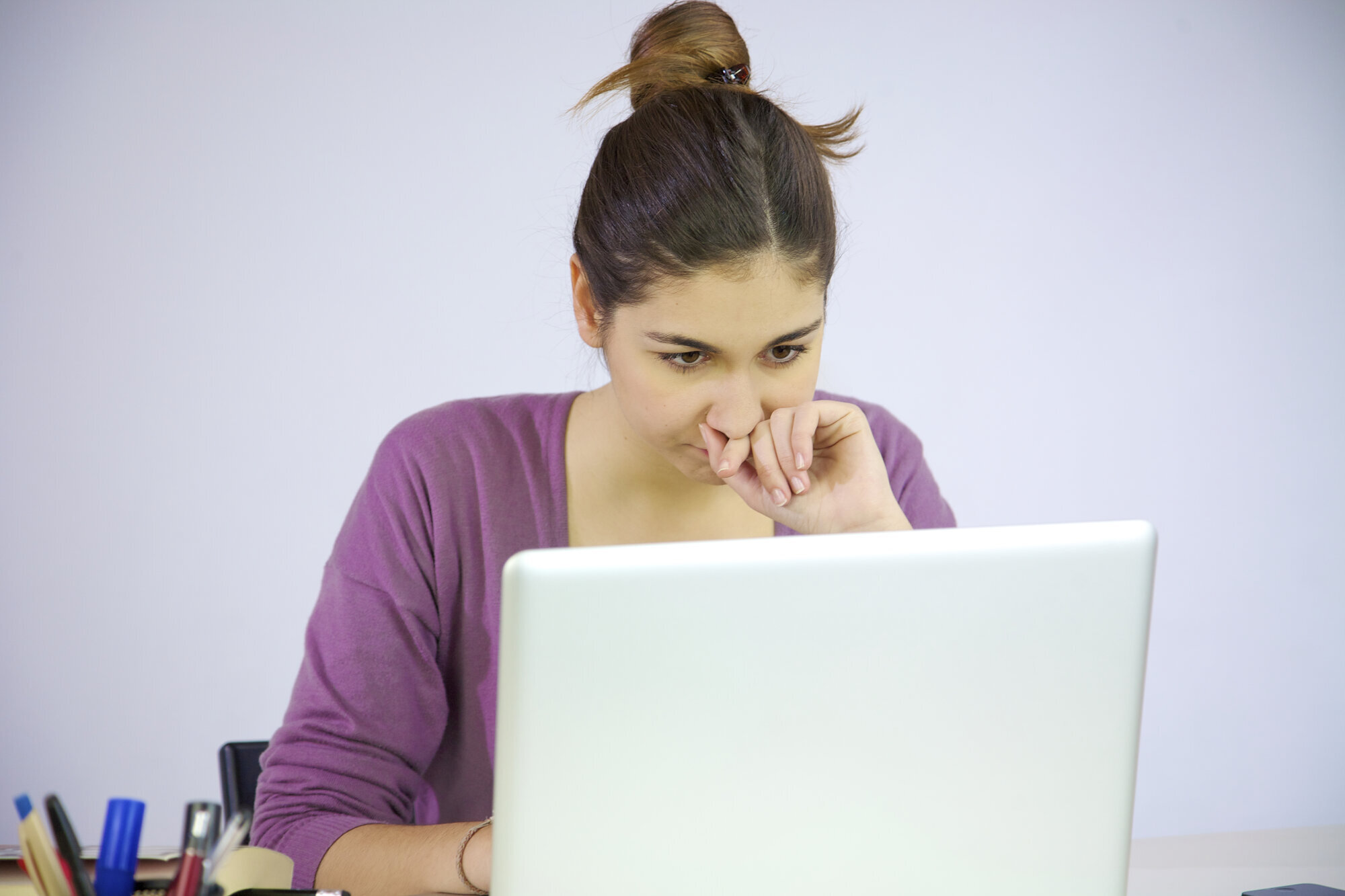 Bildet viser en kvinne som sitter ved en datamaskin.