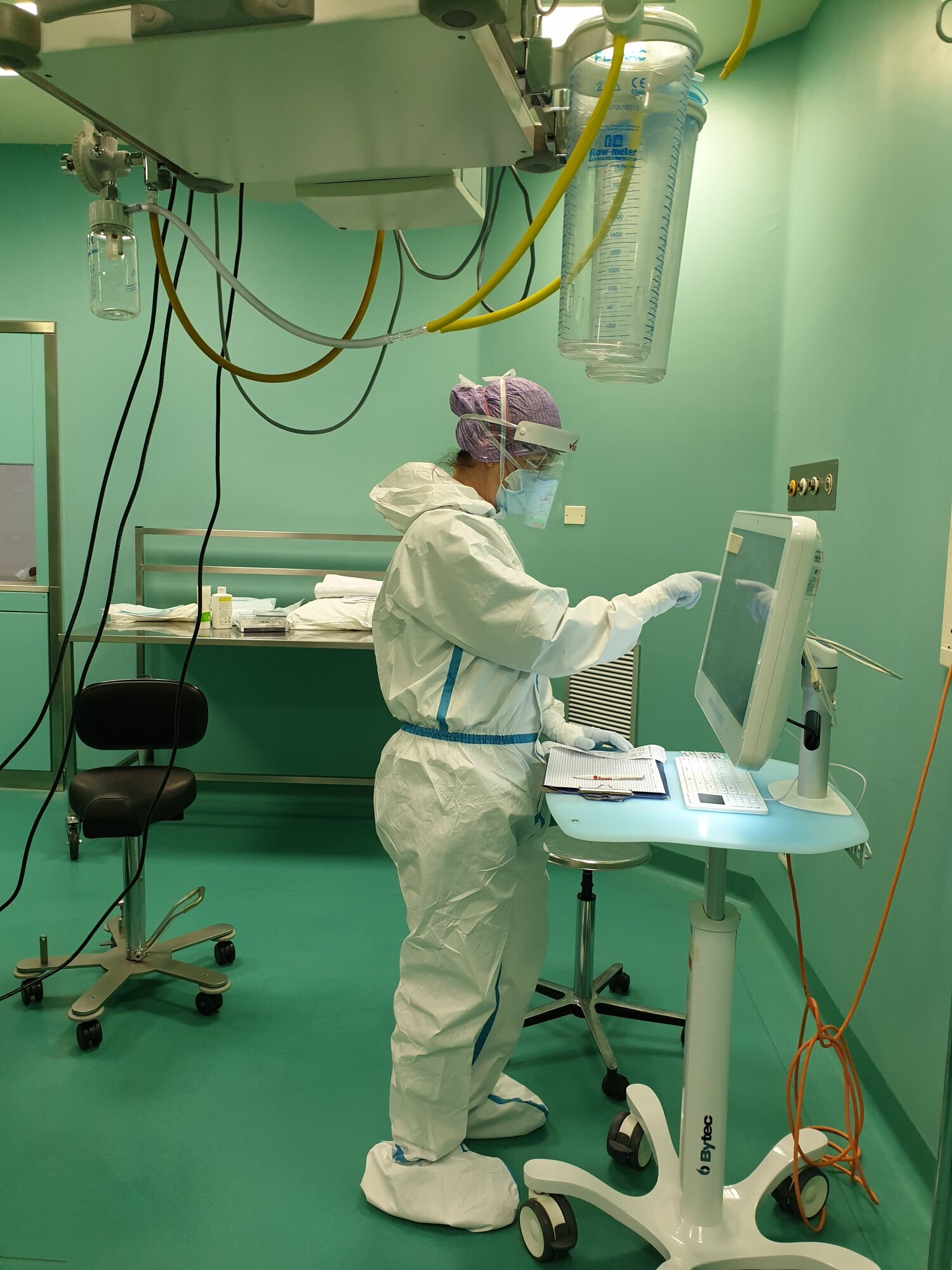 Bildet viser en sykepleiere som står og trykker på en skjerm.