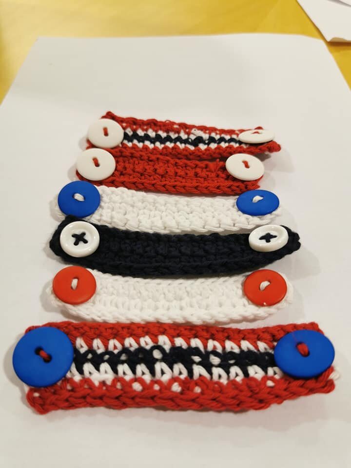 Bildet viser en slags heklete spenner med påsydde knapper.