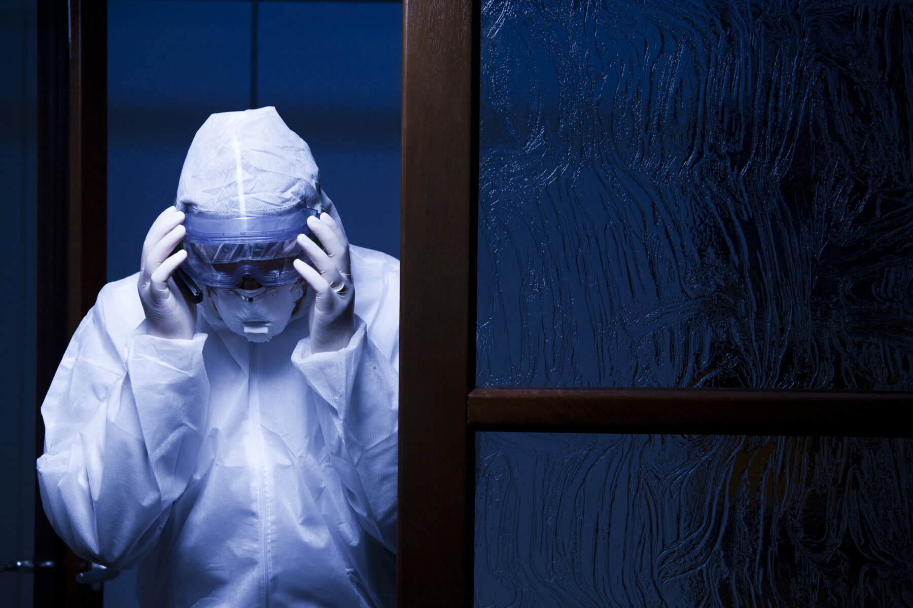 Bildet viser et helsepersonell i smittevernutstyr.