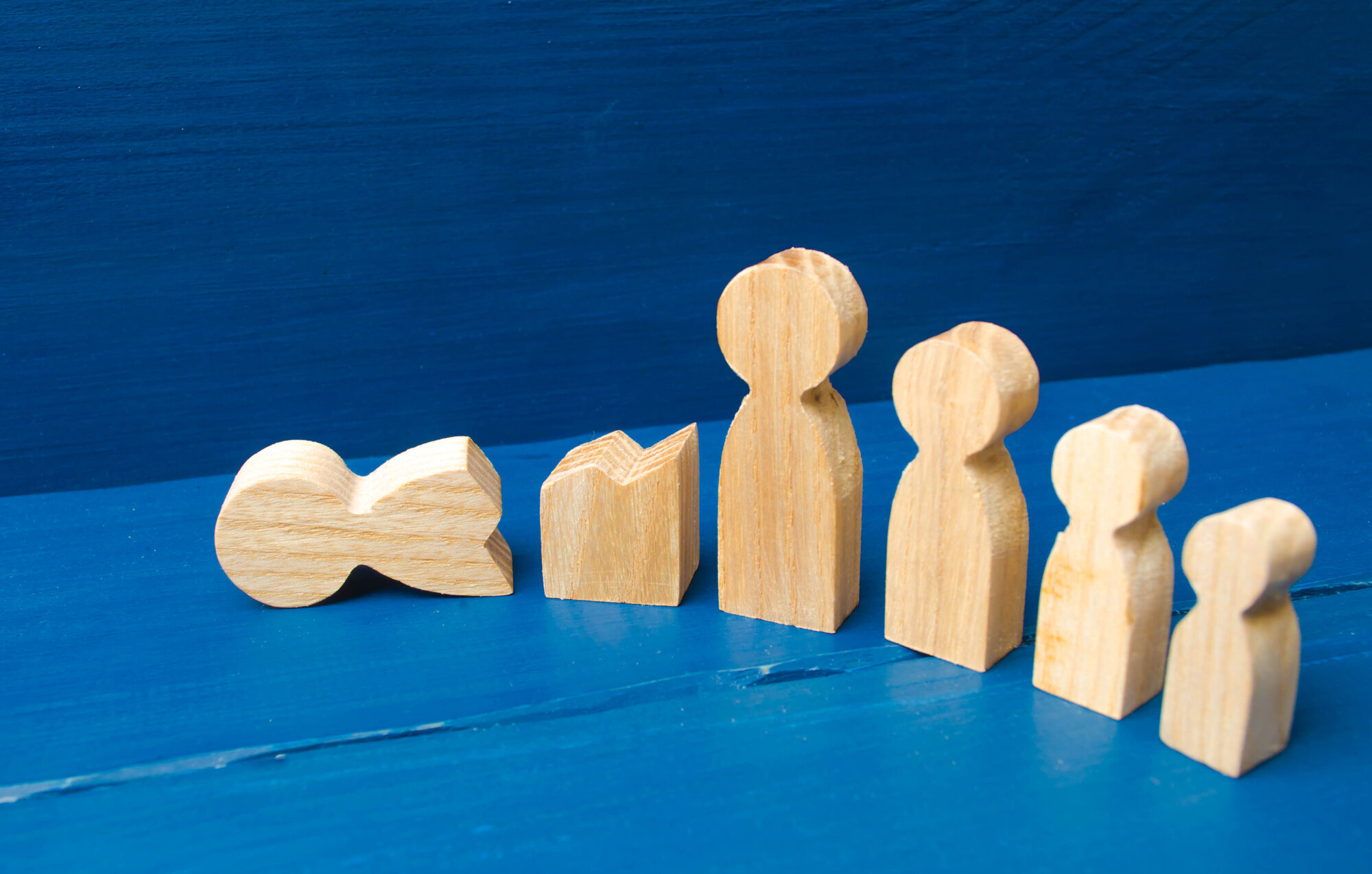 Bildet viser fem trefigurer i forskjellige størrelsen. En av figurene er ødelagt.