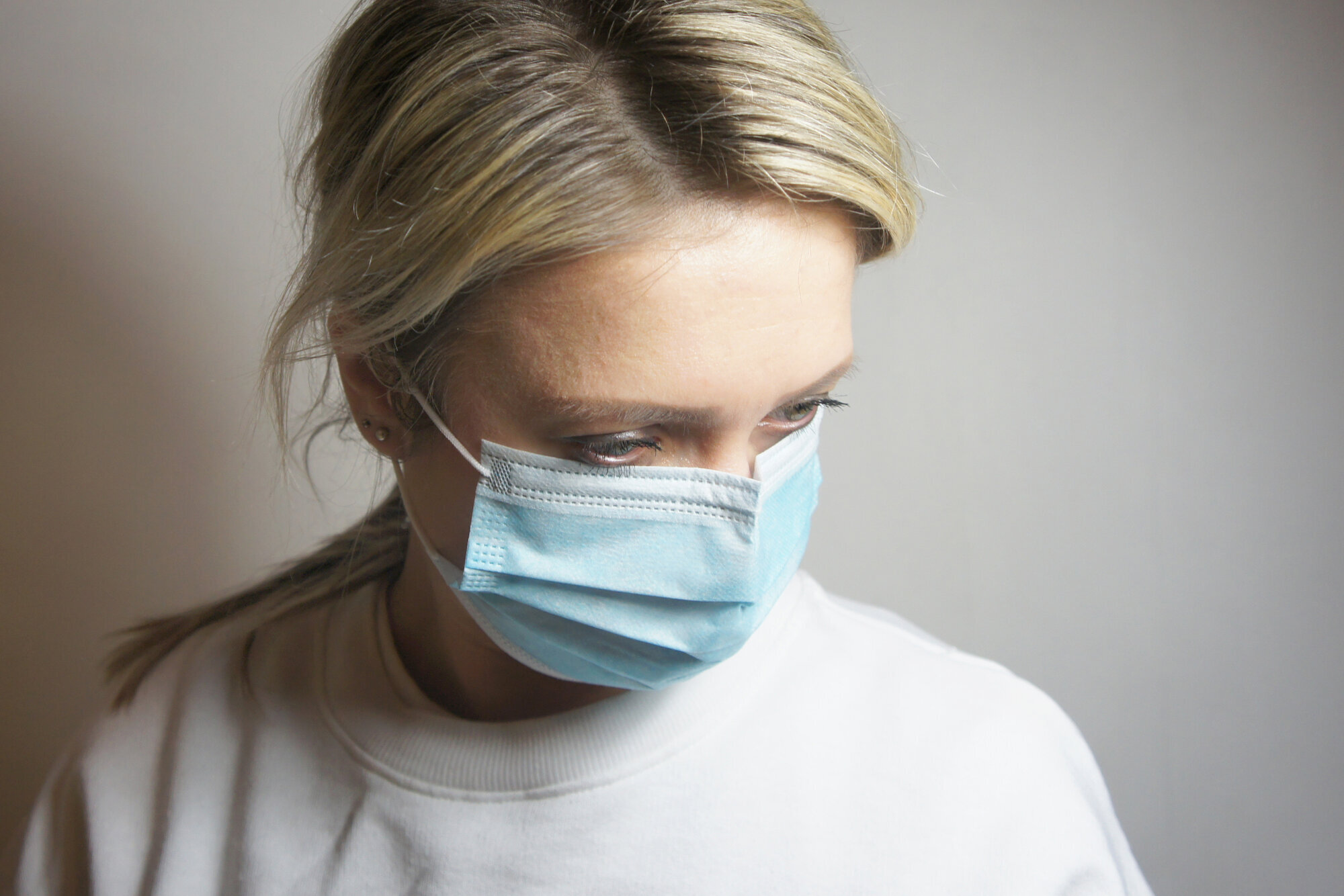 Bildet viser en kvinne med munnbind