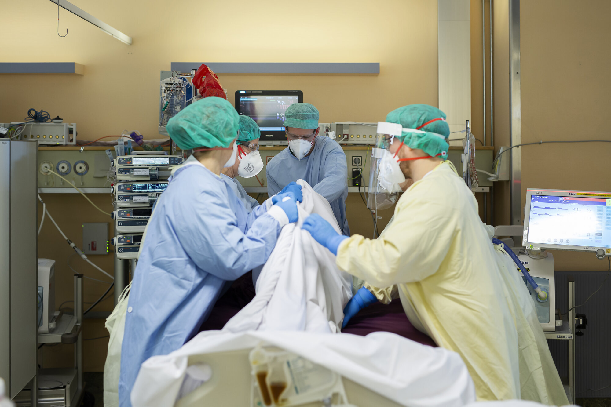 Bildet viser sykepleiere som snur en intensivpasient til mageleie