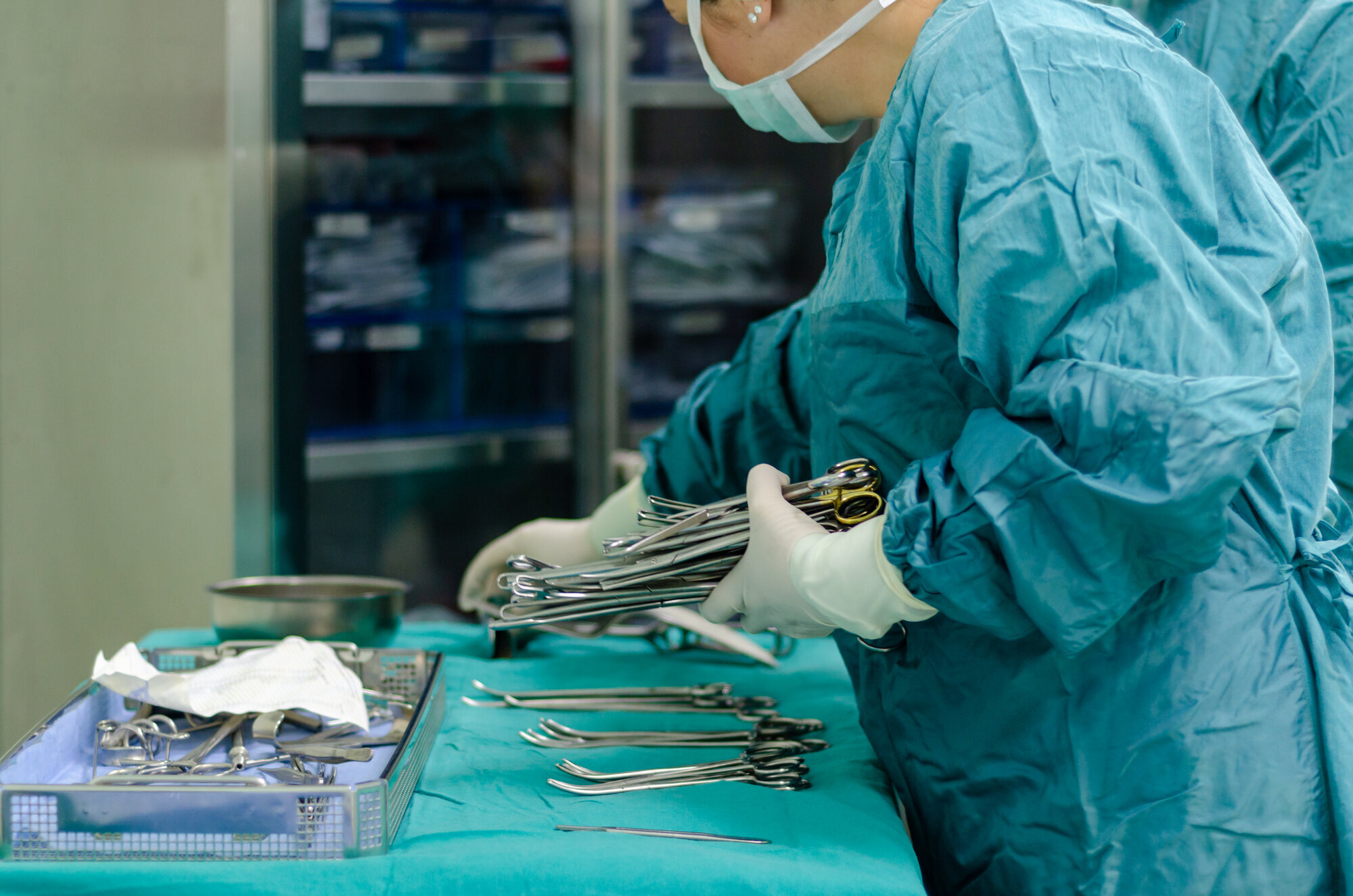 Bildet viser en sykepleier som dekker opp instrumentbordet før operasjon