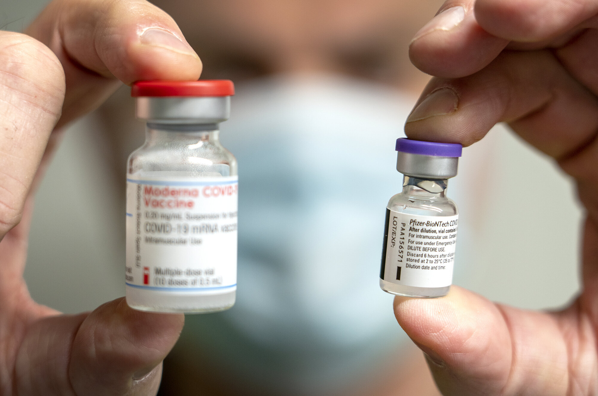 Bildet viser to hetteglass, ett med vaksine fra Pfizer/Biontech og et med vaksine fra Moderna.