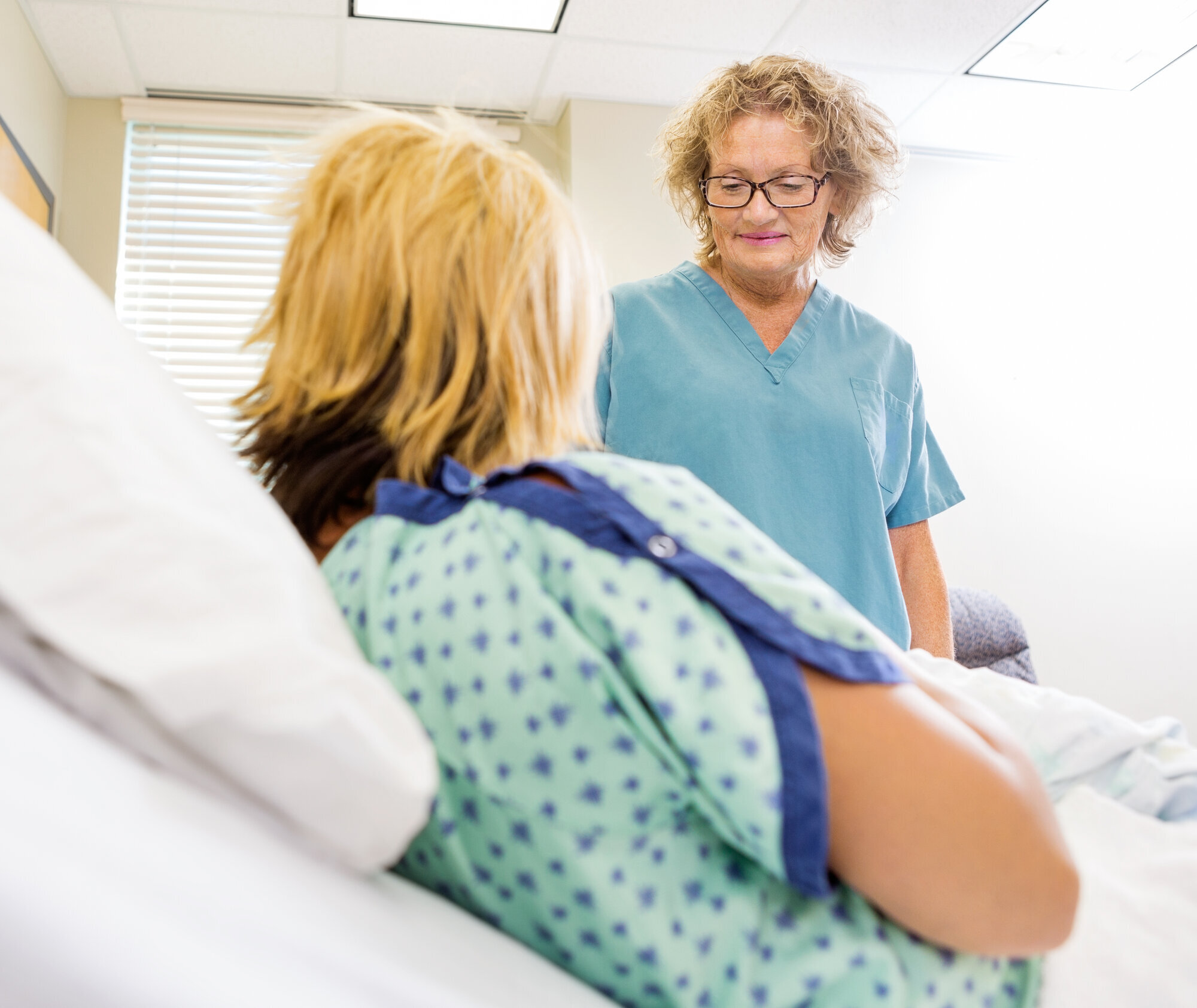 Sykepleier ser på nyfødt og moren