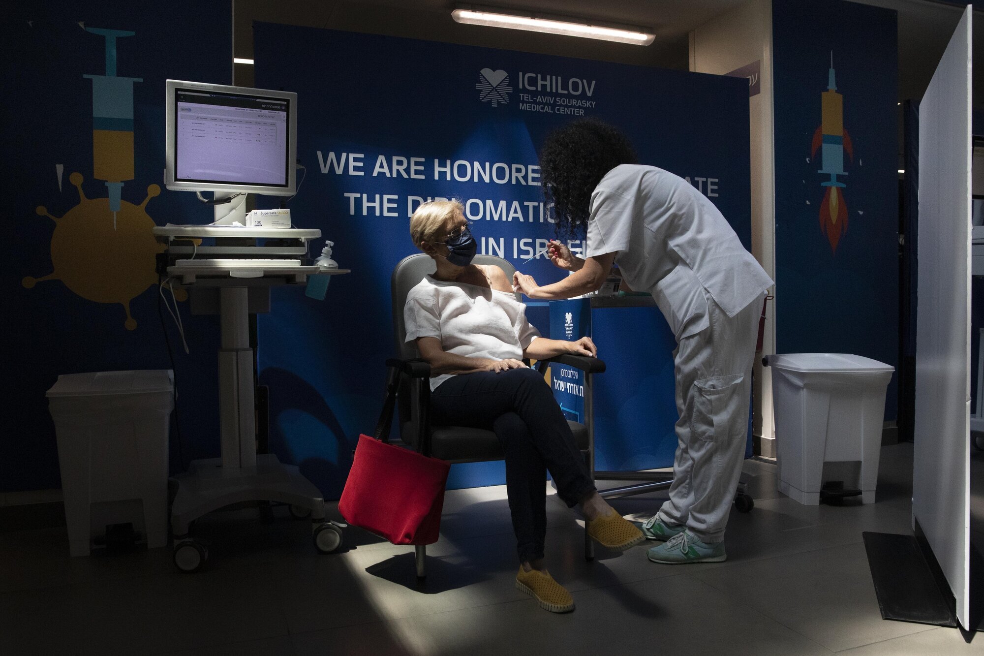 kvinne får sin tredje vaksinedose i Israel bildet viser kvinne som får sin tredje vaksinedose i Israel