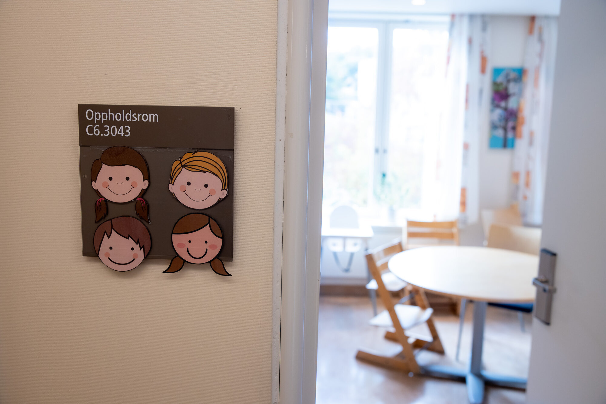 Bildet viser en åpen dør med et skilt der det står oppholdsrom, og litt av rommet.