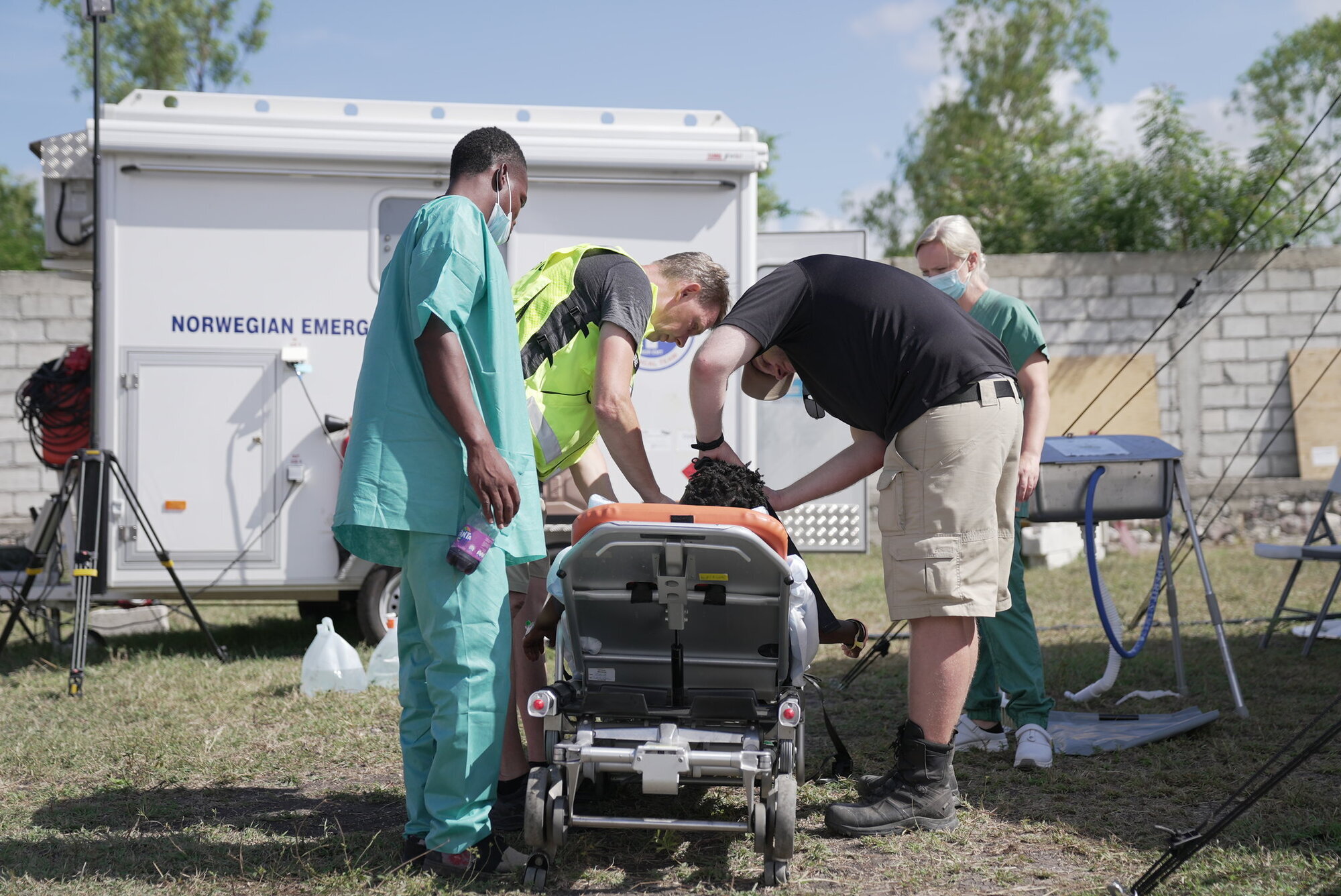 Bildet viser personell på feltsykehuset som gjør en pasient klar for transport til sykehus.