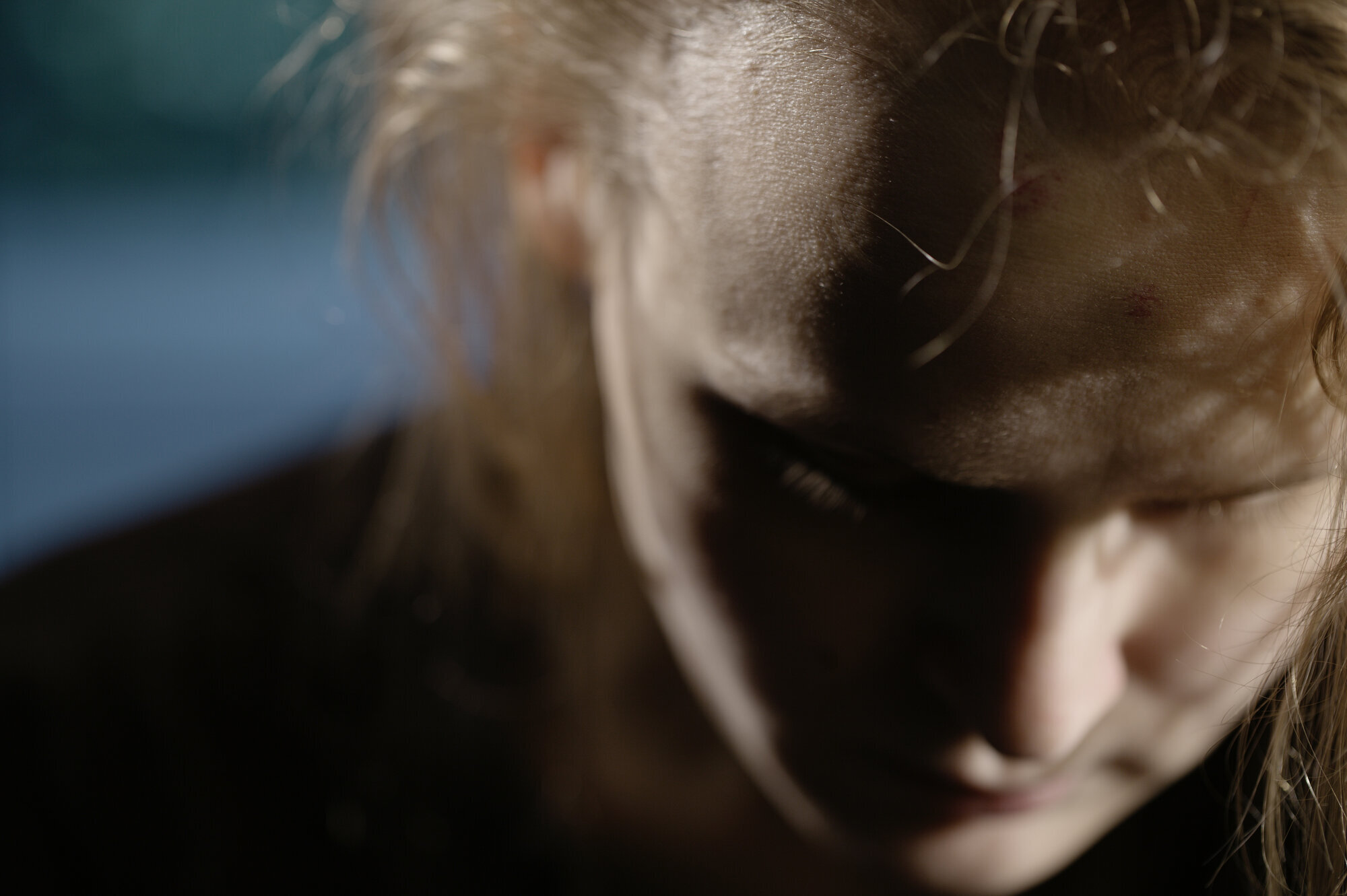 Bildet viser en kvinne med bøyd hode.