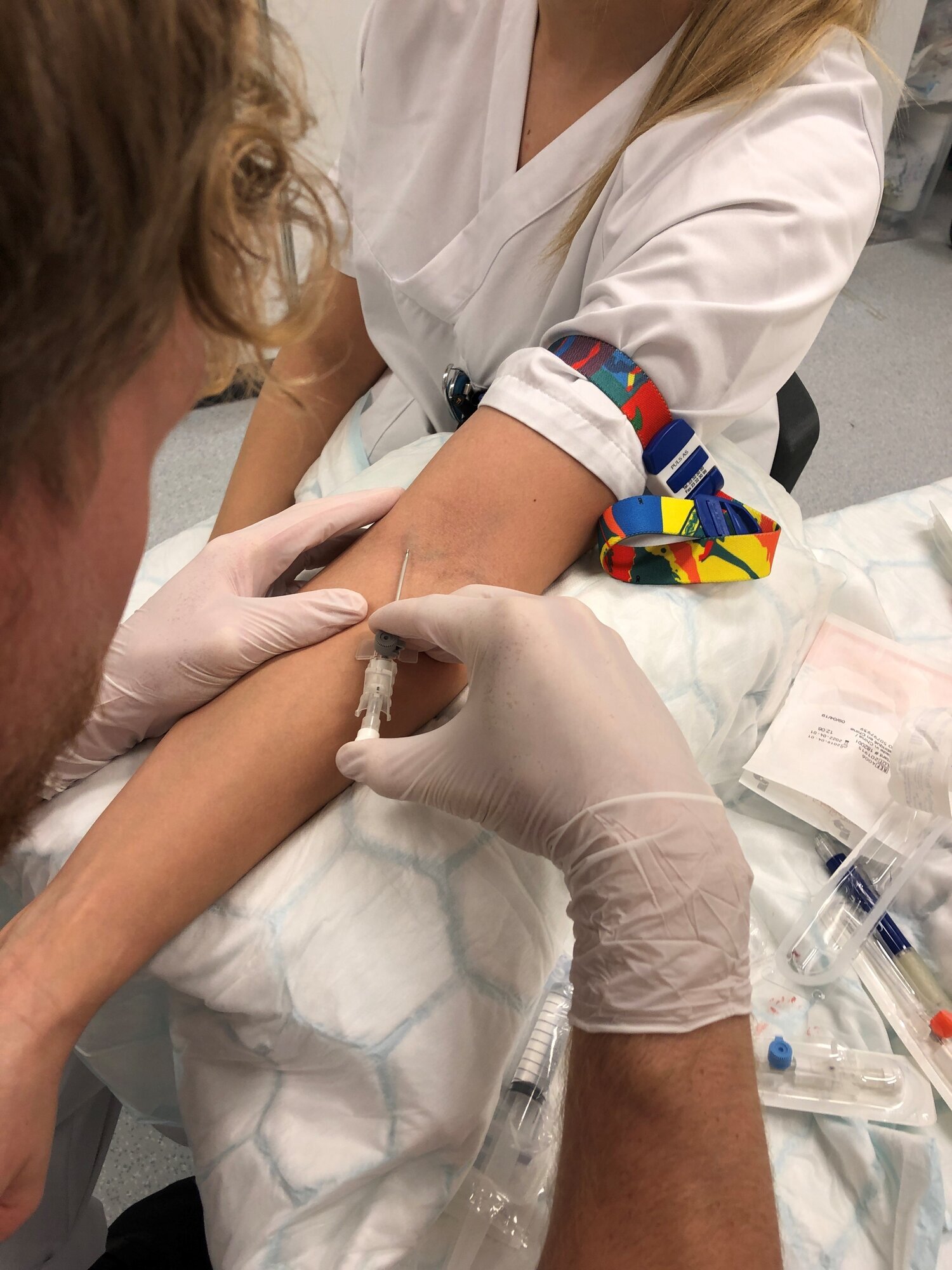 Bildet viser en sykepleier som legger inn perifert venekateter på en pasient