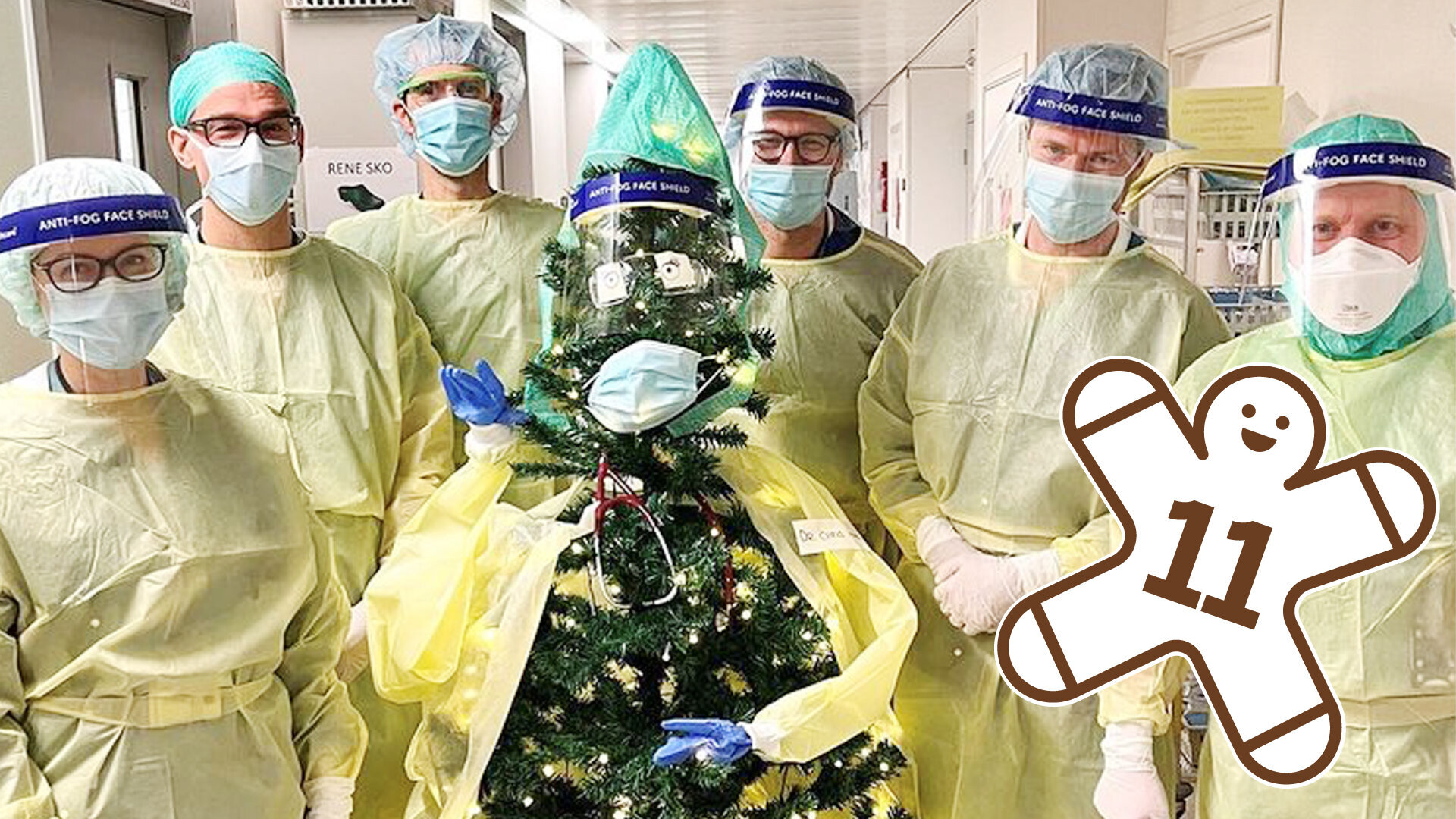 Bildet viser et juletre kledd i smittevernutstyr, omgitt av seks intensivleger.