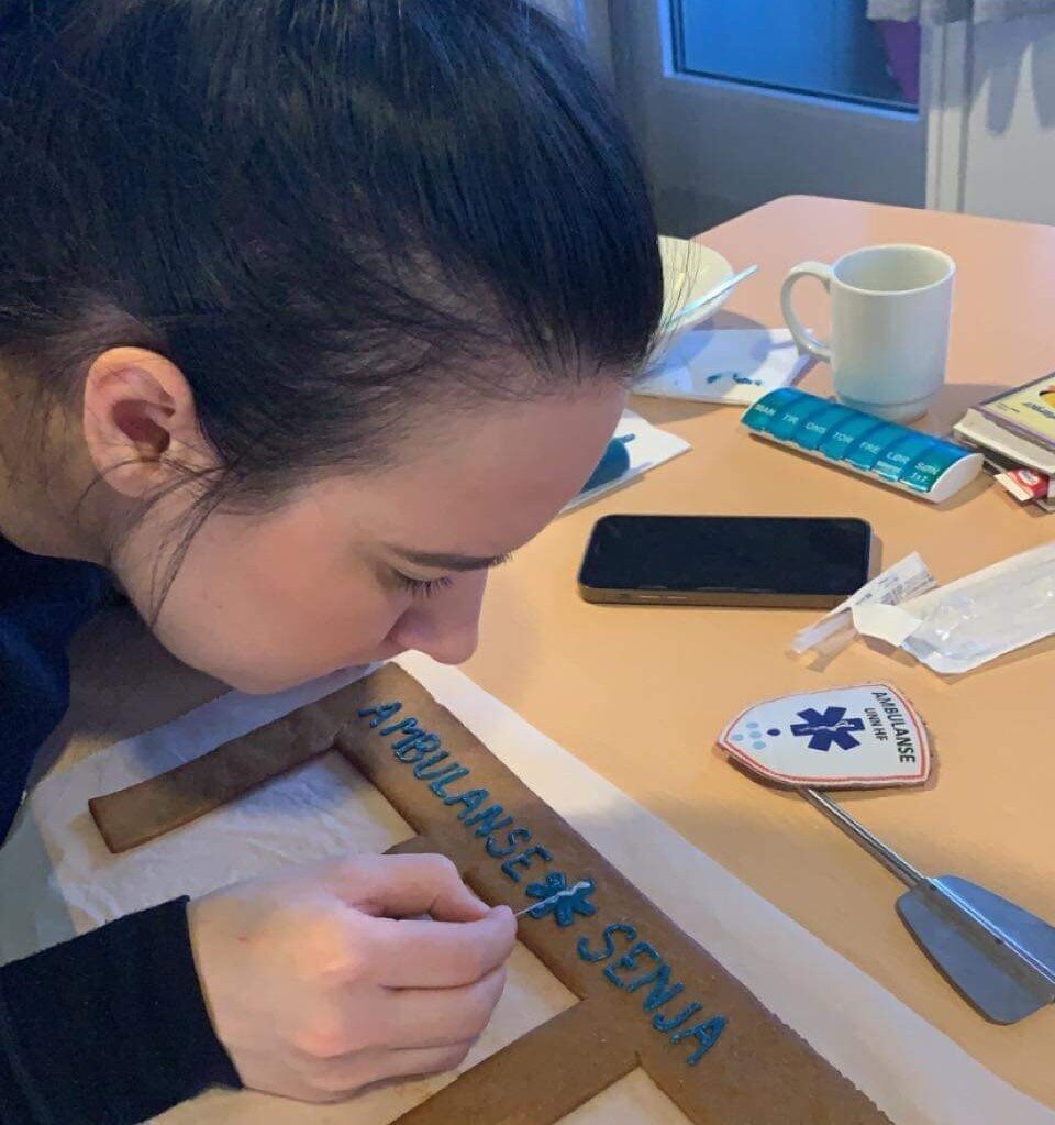 Bildet viser Ailin Waage som pynter pepperkakestasjonen.