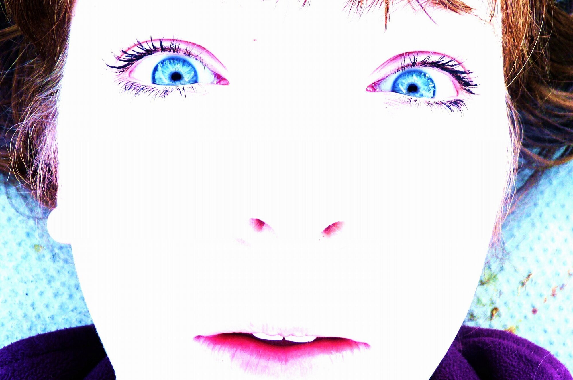 Bidet viser et kvinneansikt med oppsperrede øyne. Ansiktet ser opp i himmelen. 