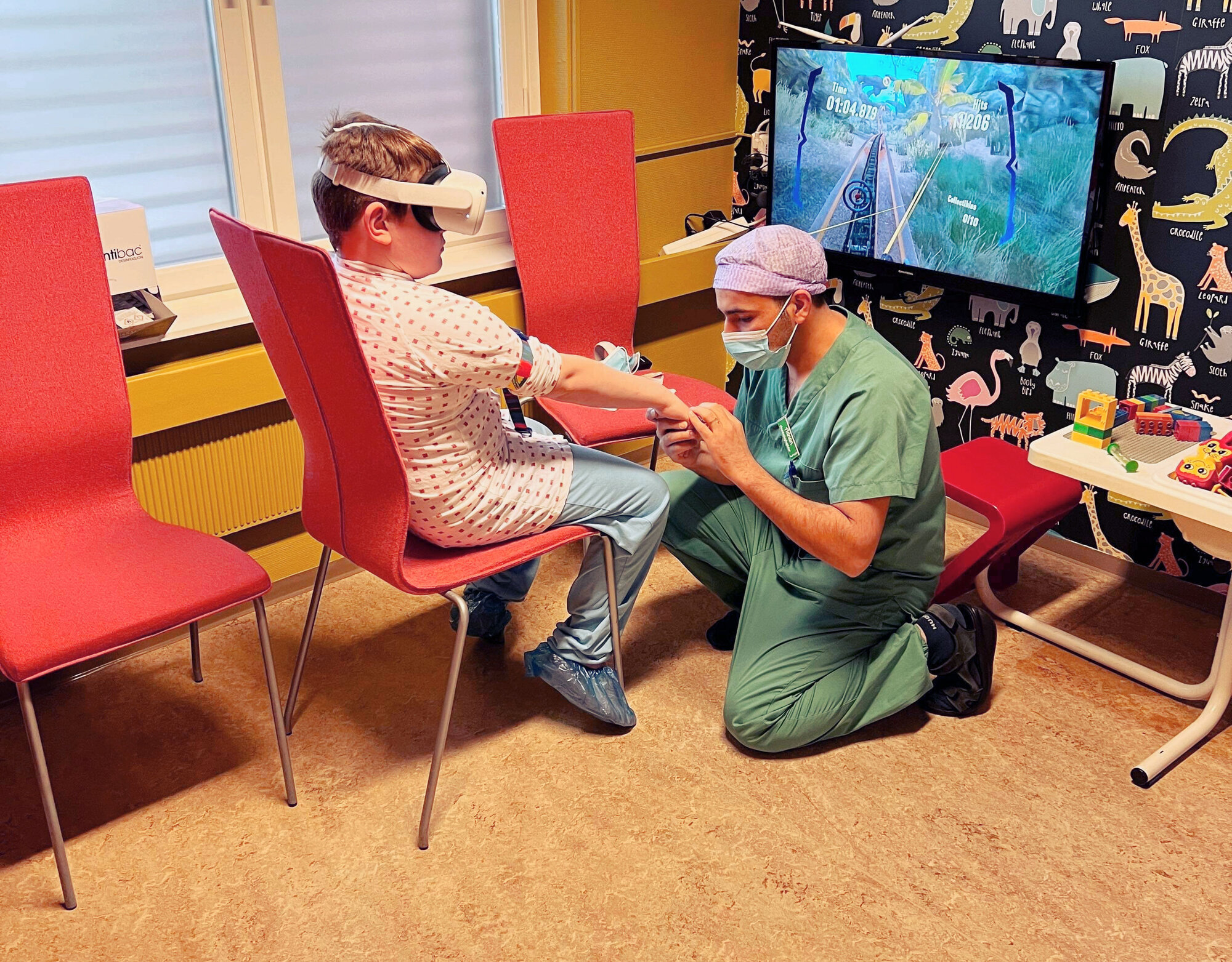  Bildet viser en gutt som har på VR-briller mens en anestesisykepleier legger inn perifert venekateter