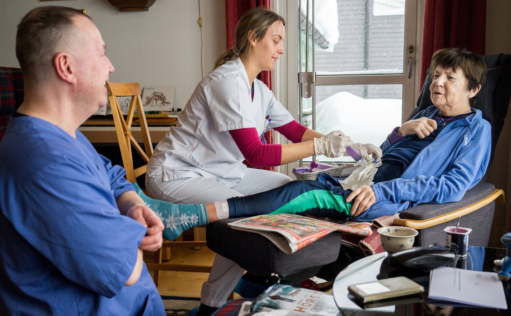 Bildet viser Anne Lise Strand med hjemmesykepleien på besøk