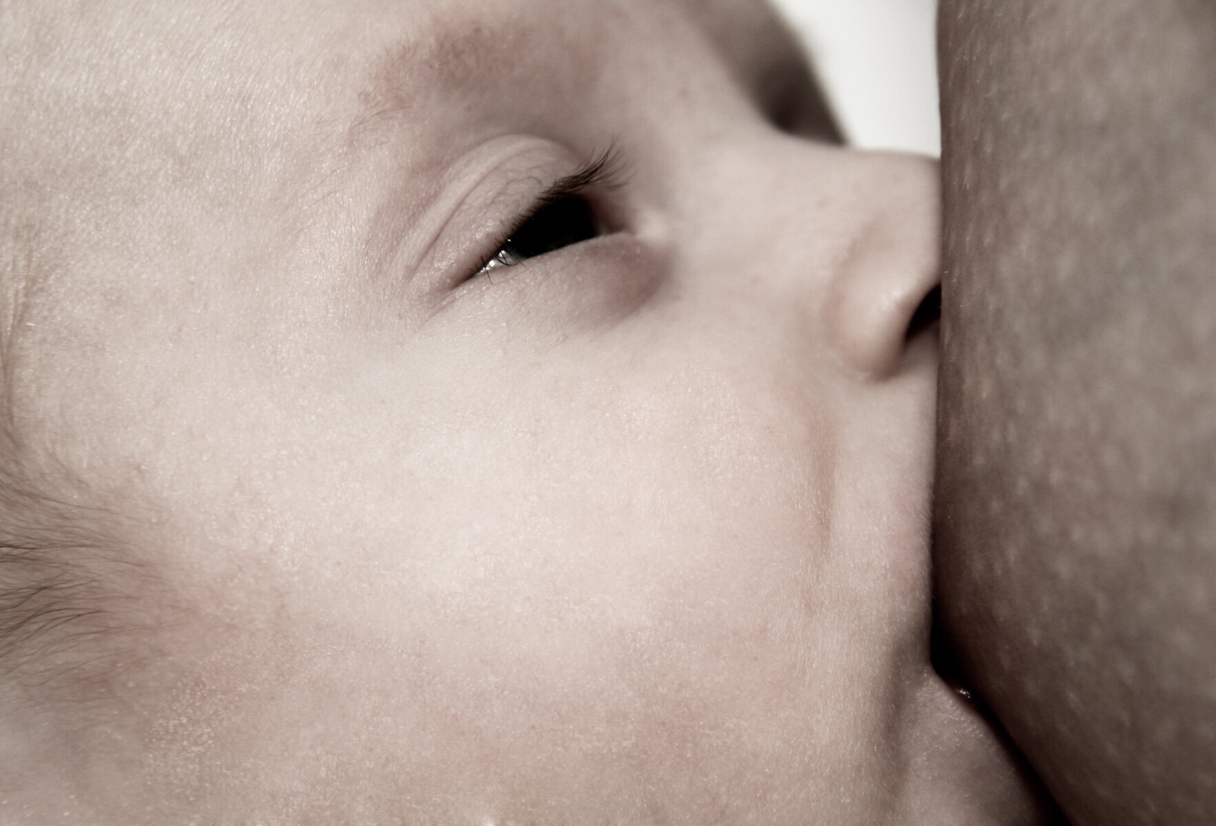 Bildet viser en baby som ammer