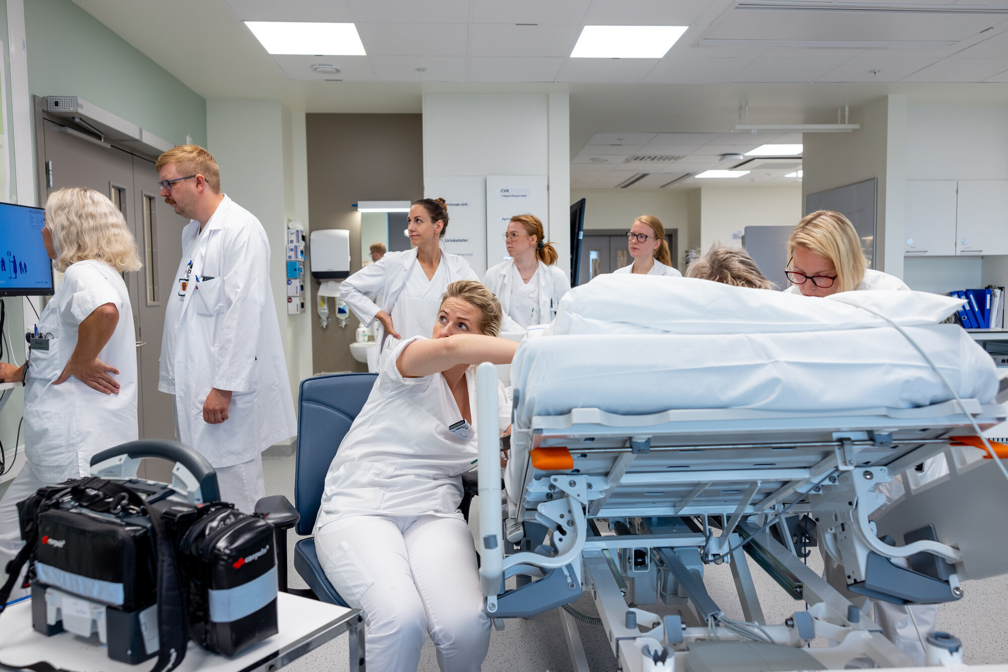 bildet viser mange helsepersonell rundt en pasient