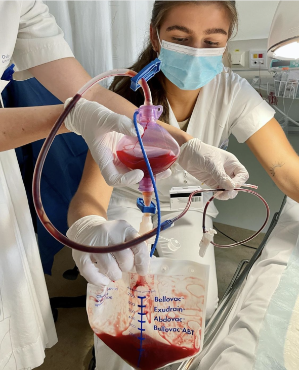 Bildet viser to sykepleiere som holder på med dren.