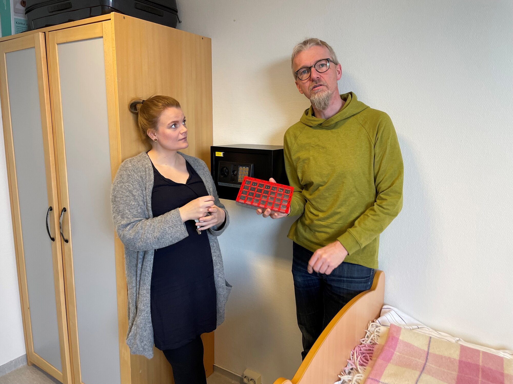 Bildet viser to personer, hvorav en viser frem en dosett.