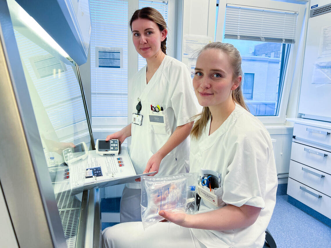Bildet viser to kvinnelige sykepleiere som holder i medisinsk utstyr