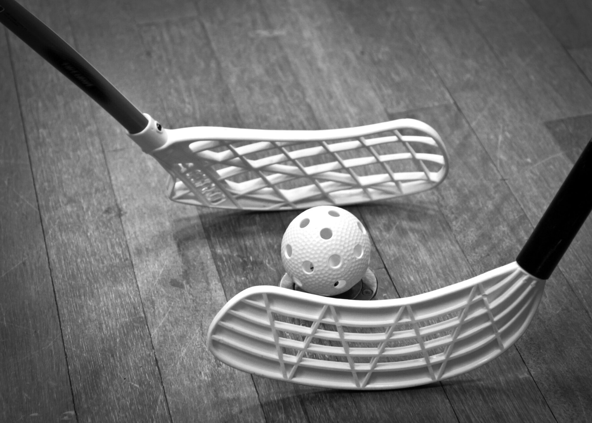 Bildet viser to innebandykøller og en ball