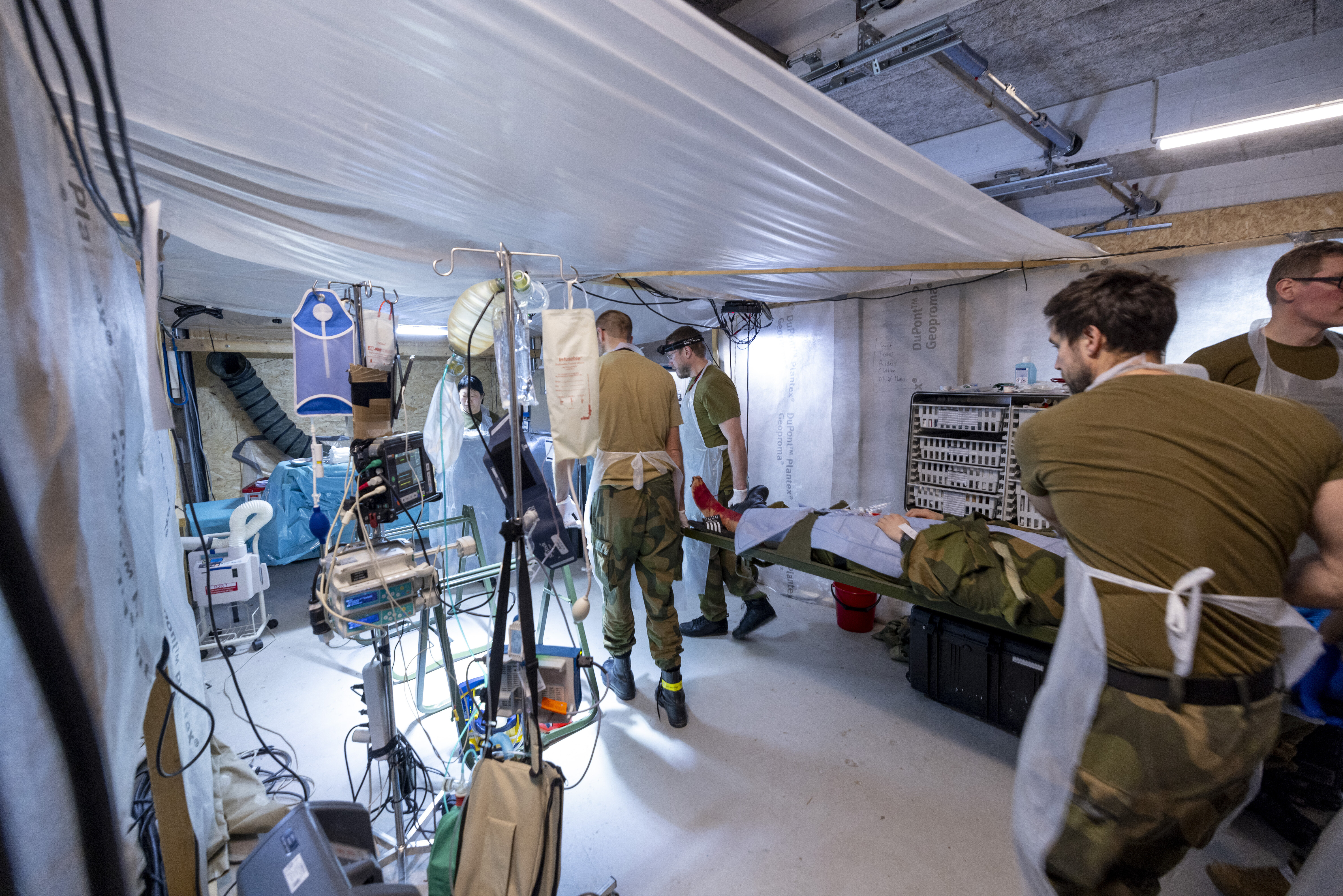 Bildet viser sanitetspersonell som bærer en pasient på båre.