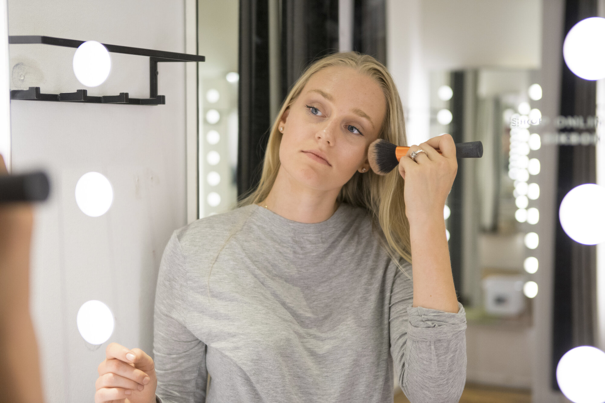 Bildet viser en ung kvinne som sminker seg.