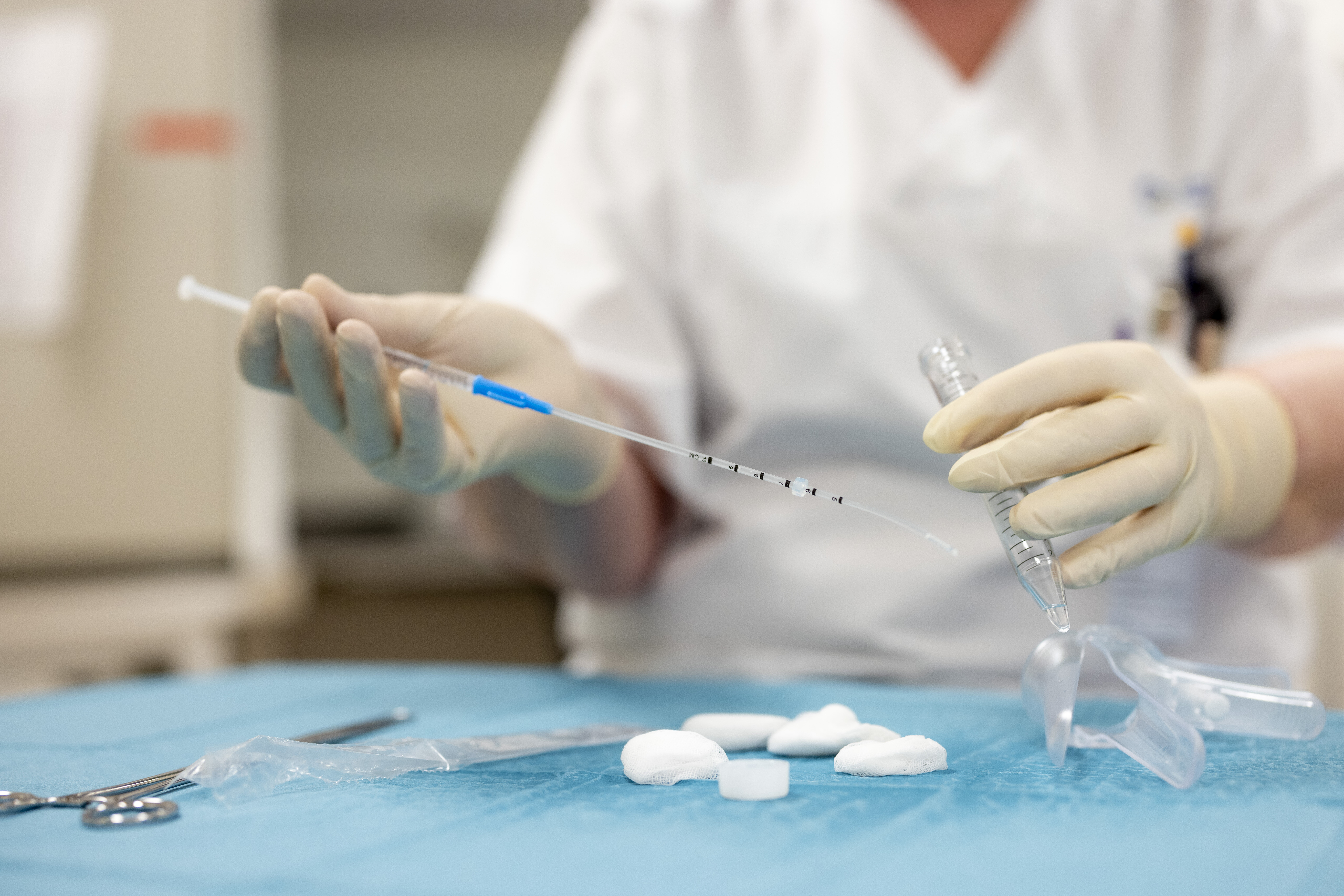 Bildet viser hender som holder utstyr til inseminering.