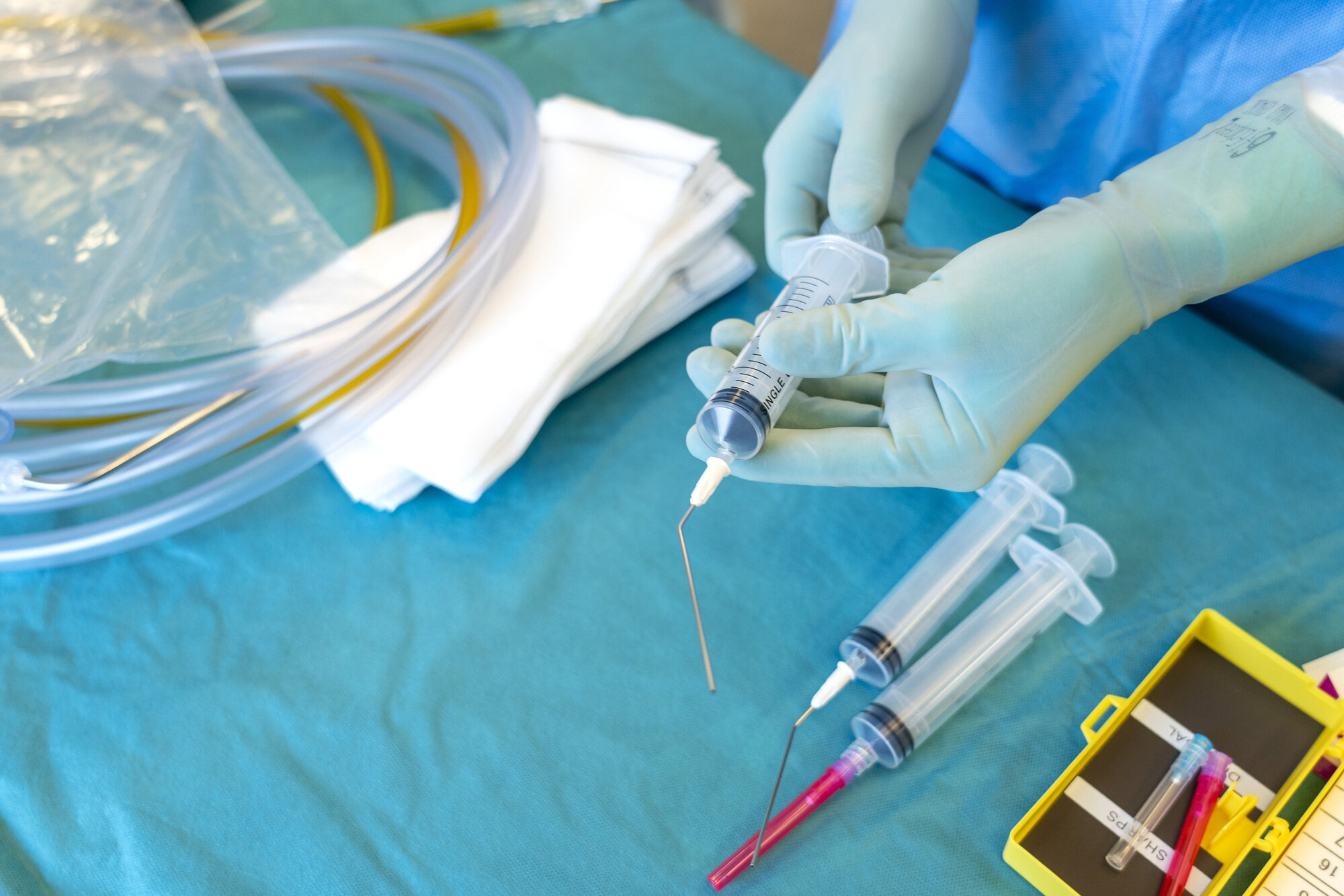 Bildet viser hender som gjør klart utstyr til operasjon