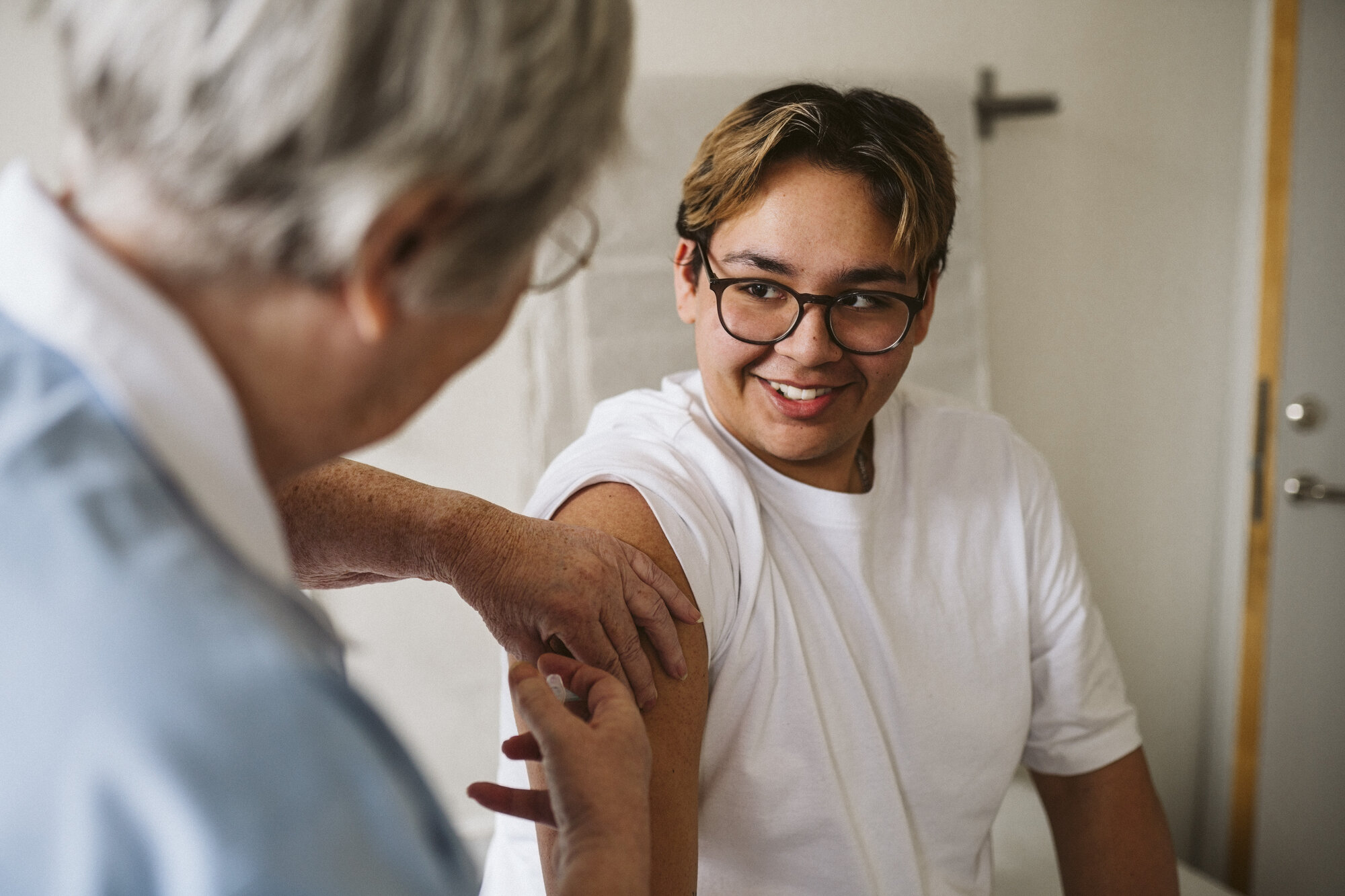 Bildet viser en ung mann som får vaksine