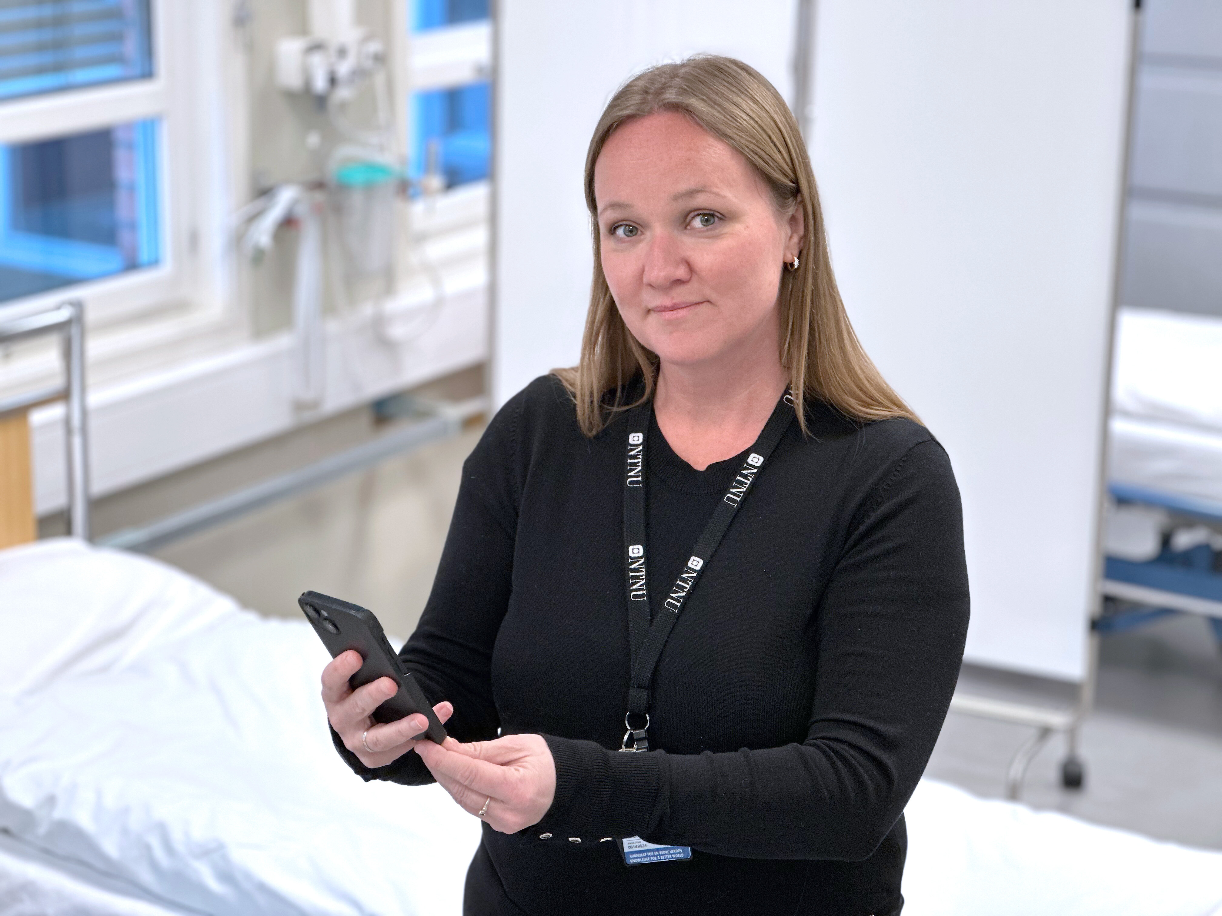 Bildet viser innleggsforfatteren som holder en mobil