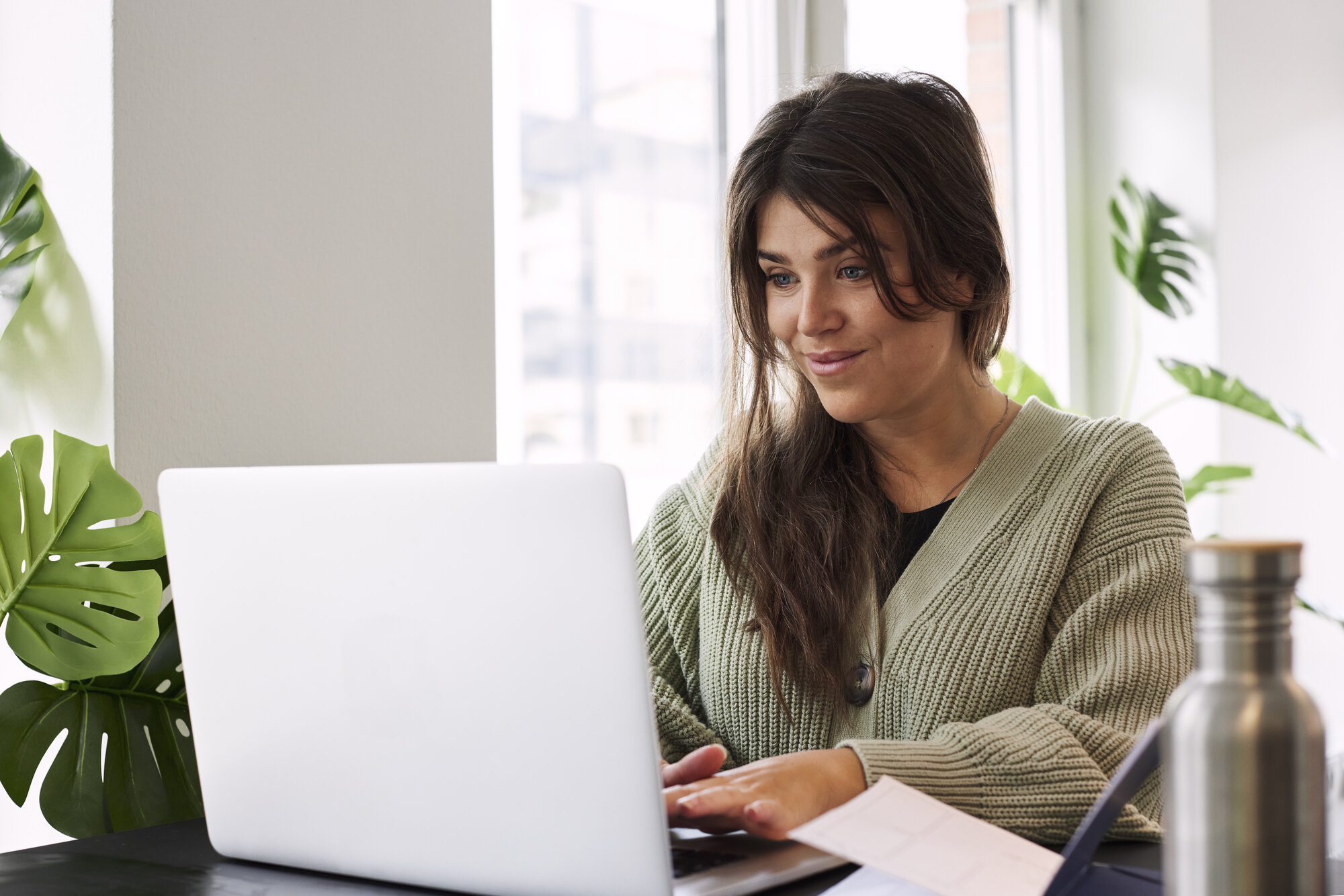 Bildet viser en student som sitter på laptopen sin hjemme