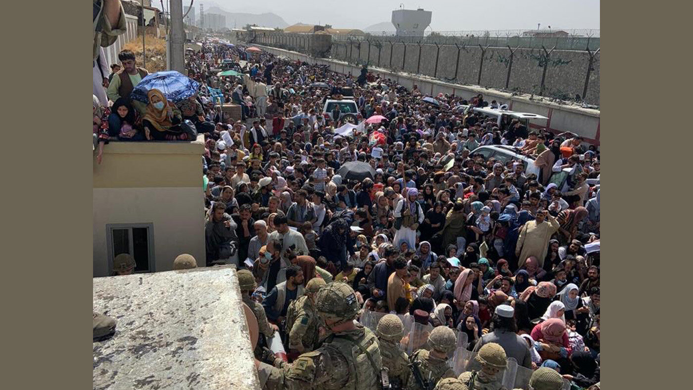 Bildet viser mennesker utenfor porten til feltsykehuset.