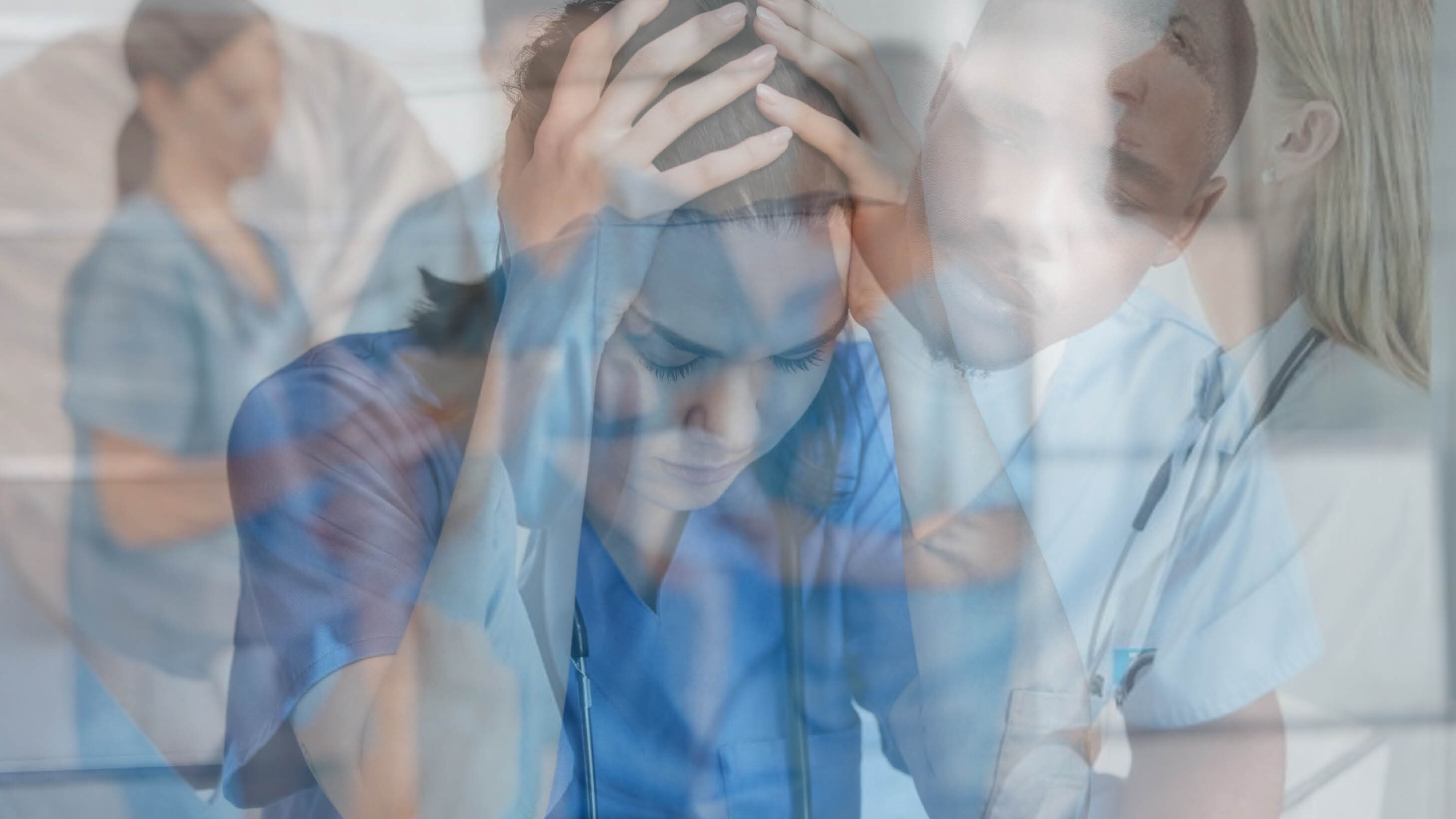 The photo shows a montage of various nurses. A woman in front of the photo is holding her hands on her heads. She seems to be in despair.