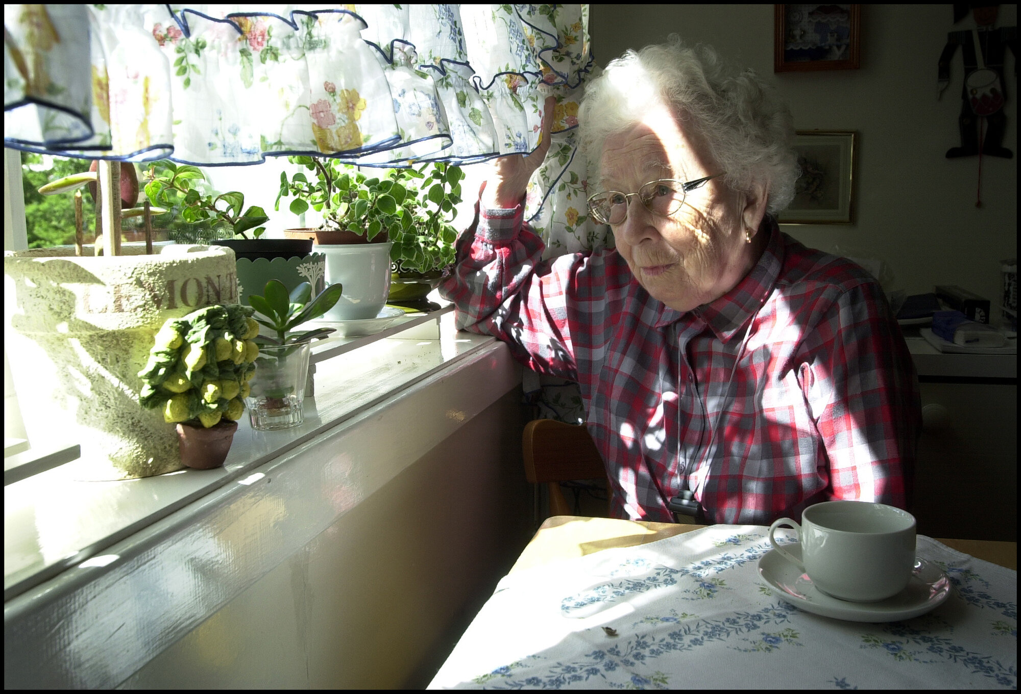 Illustrasjonsfoto: Eldre dame ser ut av vinduet.