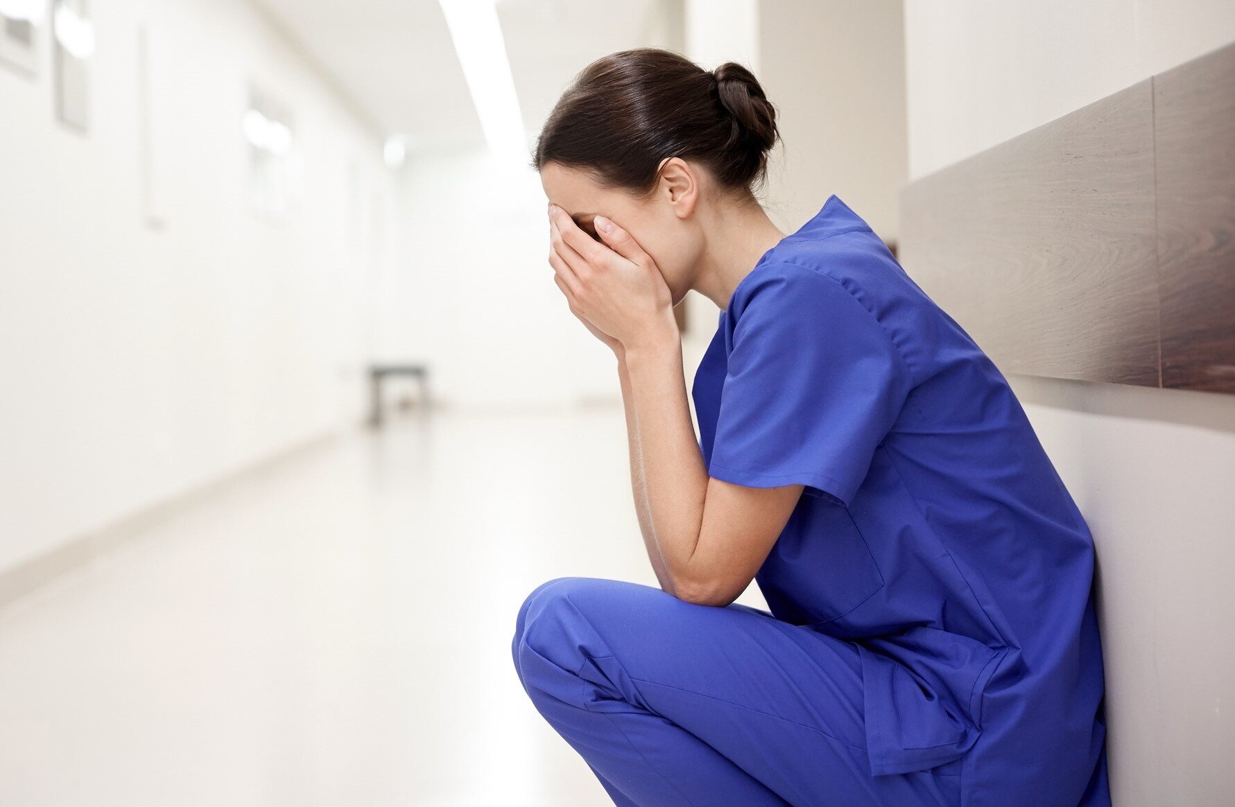 Bildet viser en stresset og sliten sykepleier