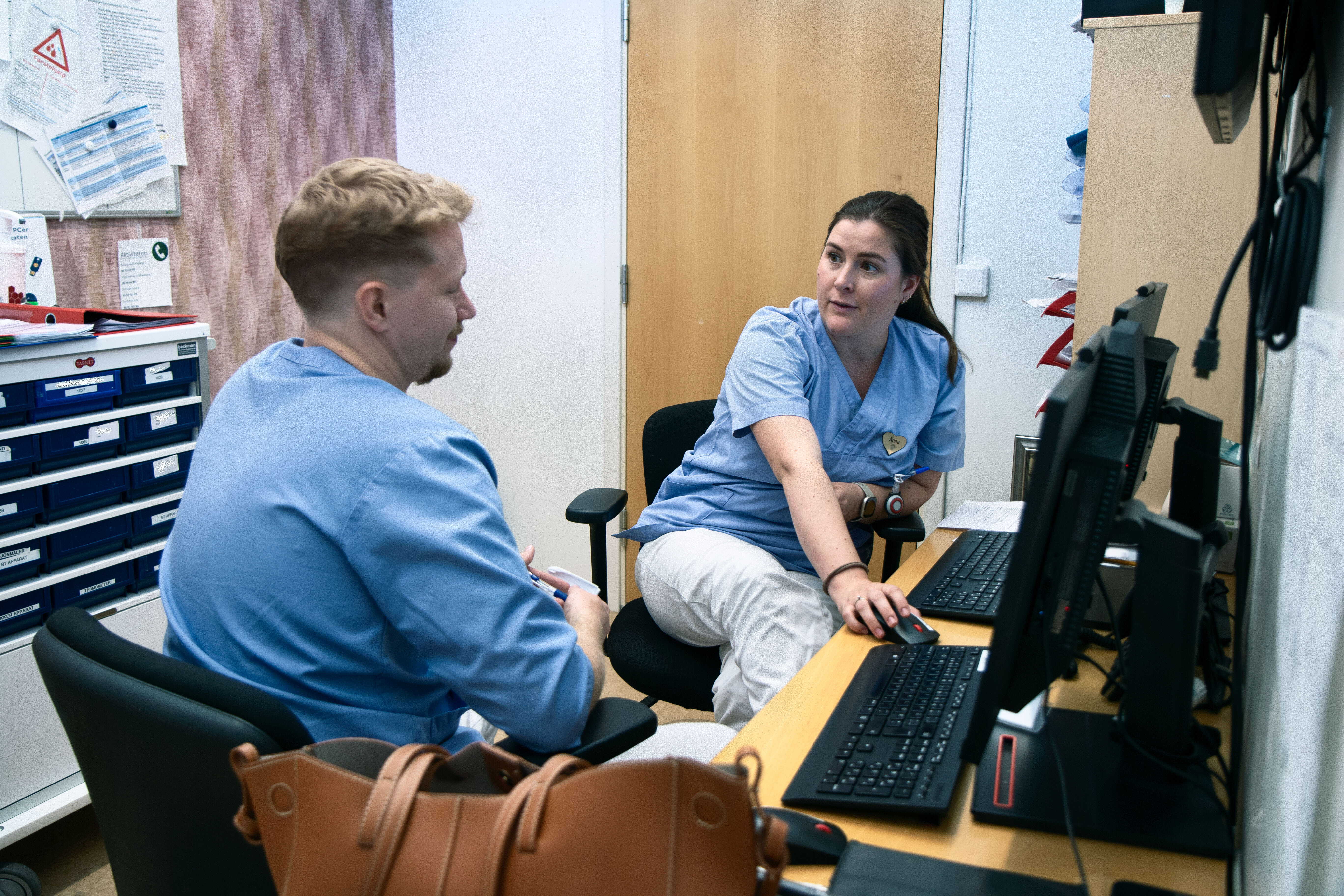 Bildet viser sykepleier og lege som har legevisitt foran pc 