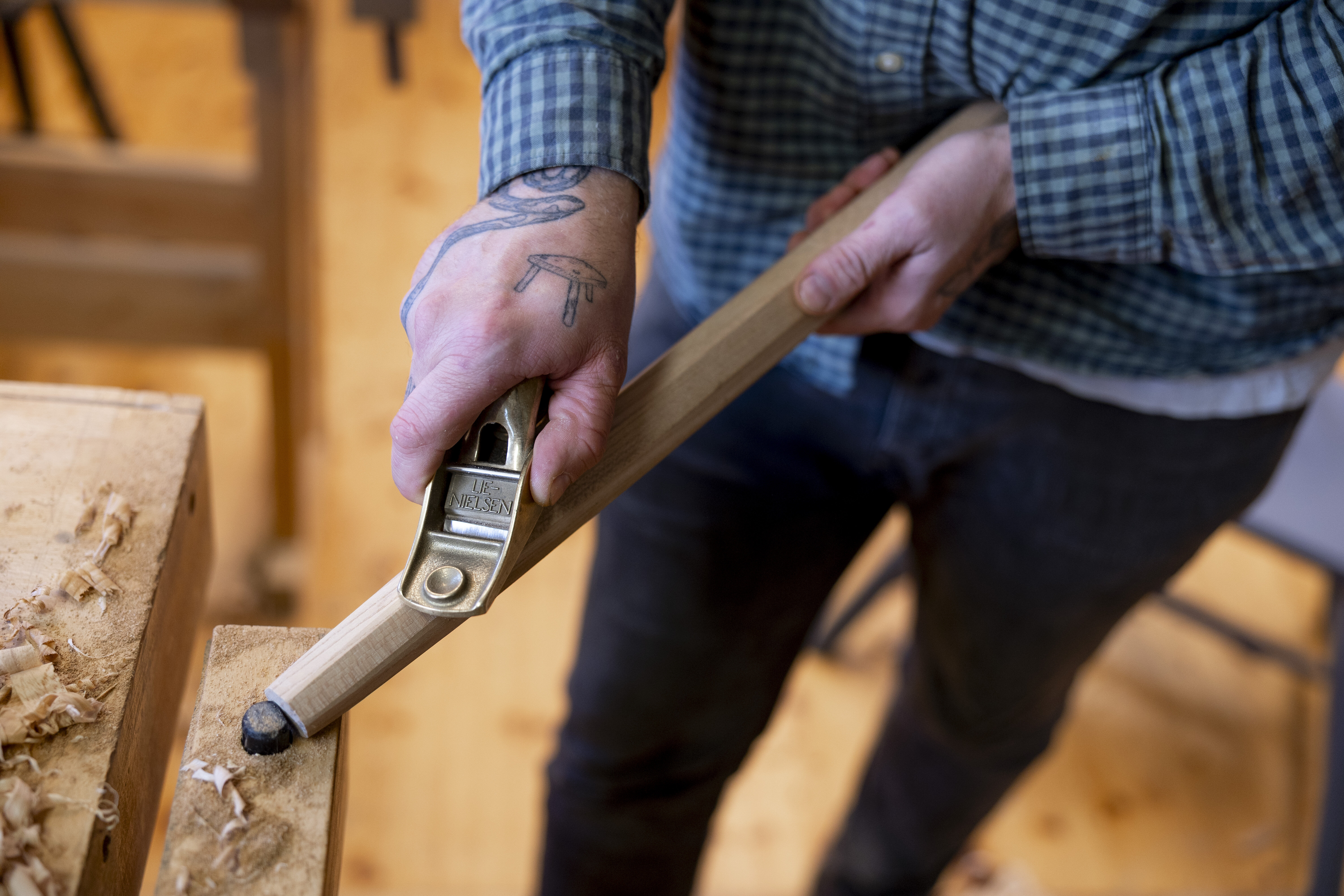 Bildet viser Klaus Skrudland som bruker håndhøvel på et stolben.