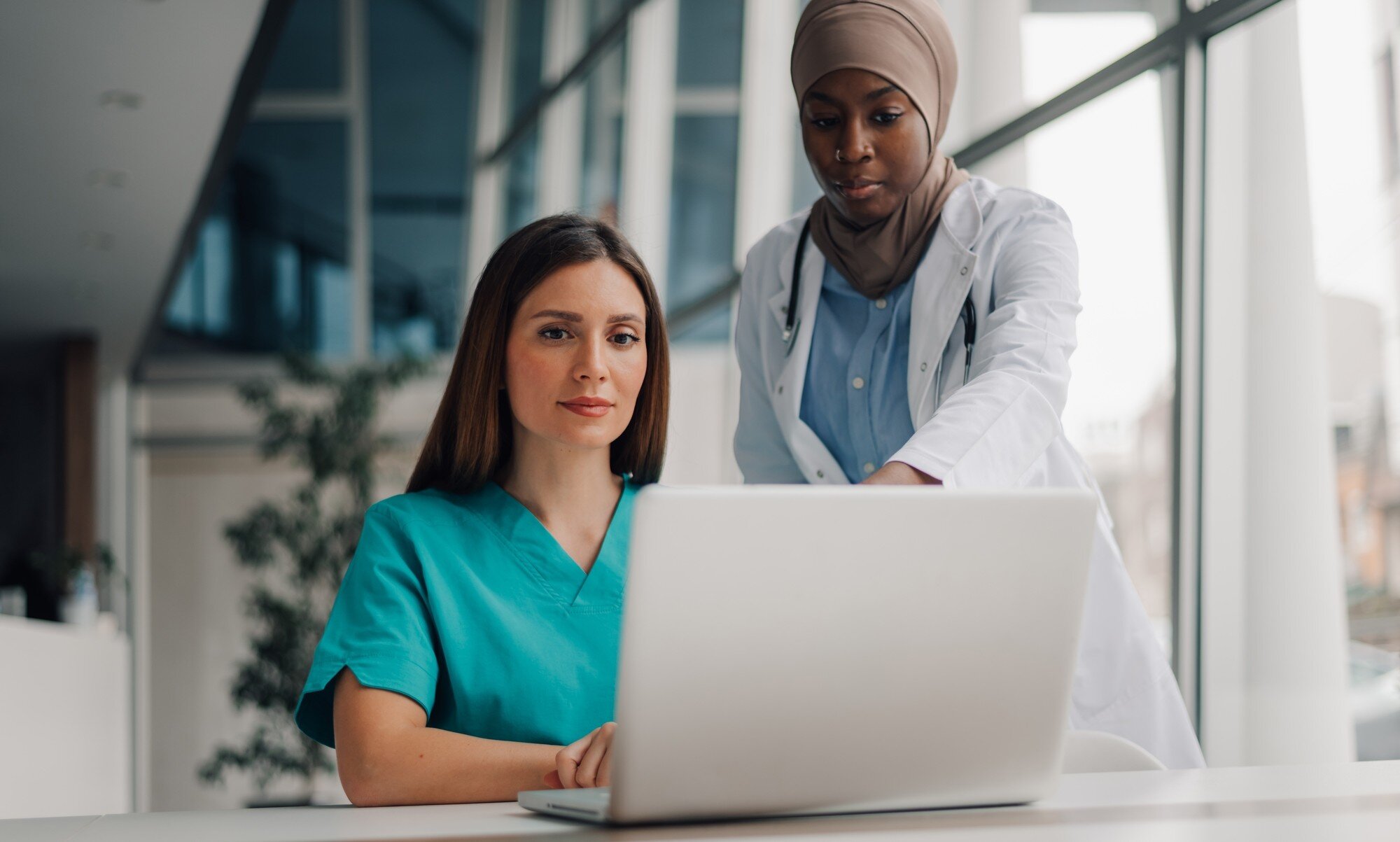 Bildet viser en sykepleier som får digital opplæring av en leder