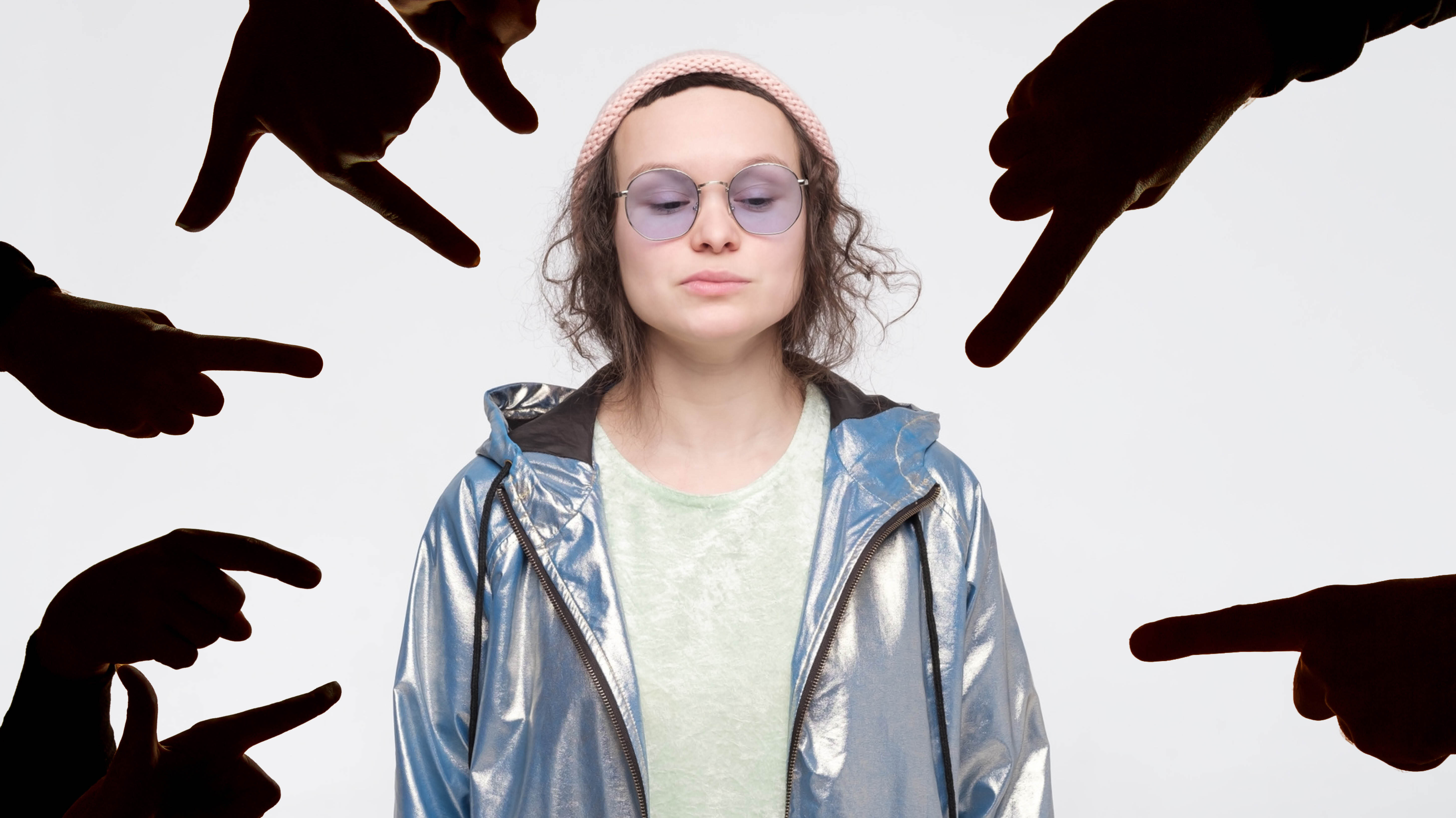 Bildet viser et bilde av en unge jente som står rett opp og ned mens fingre peker på henne.