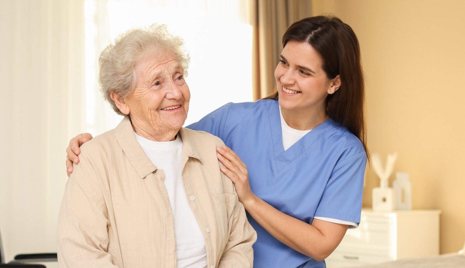 Bildet viser en sykepleier som viser omsorg for en eldre pasient