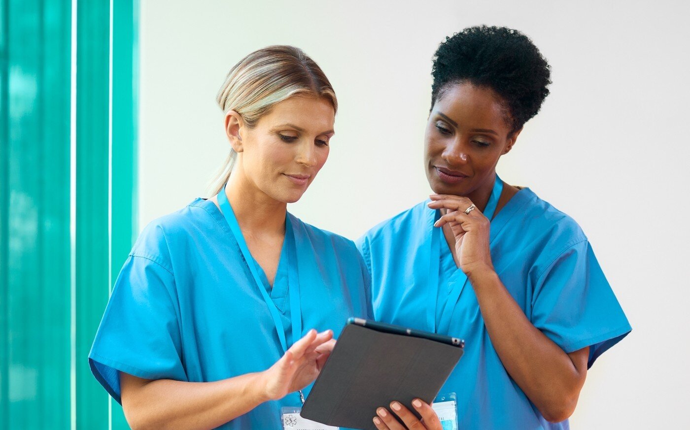 Bildet viser to sykepleiere som bruker en iPad