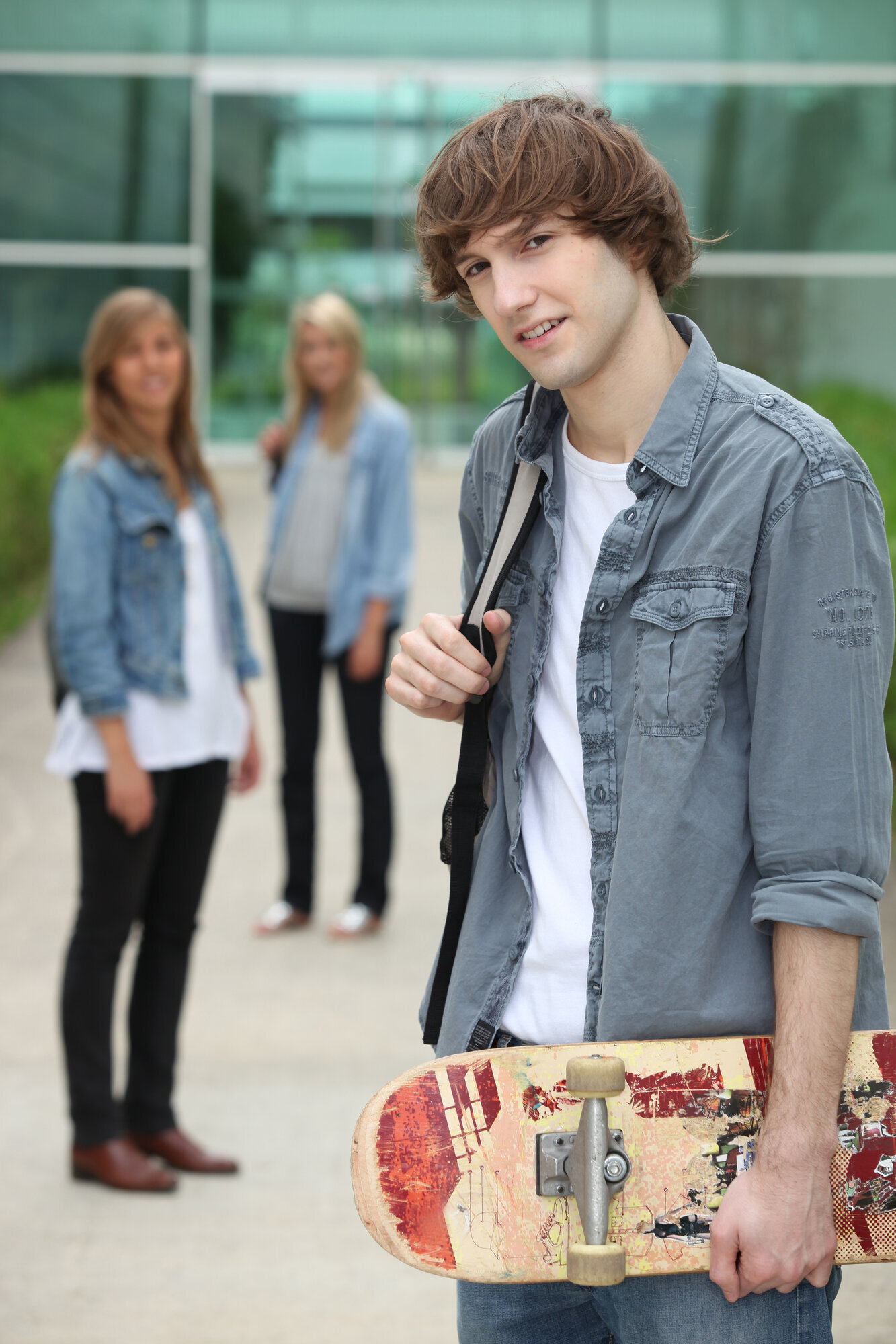 Bilde av en ung mann med skolesekk, og to unge kvinner i bakgrunnen.