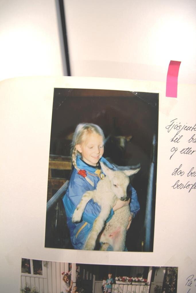 Bildet viser Frøya Marie Vinjar Eid som barn mens hun holder et lam.