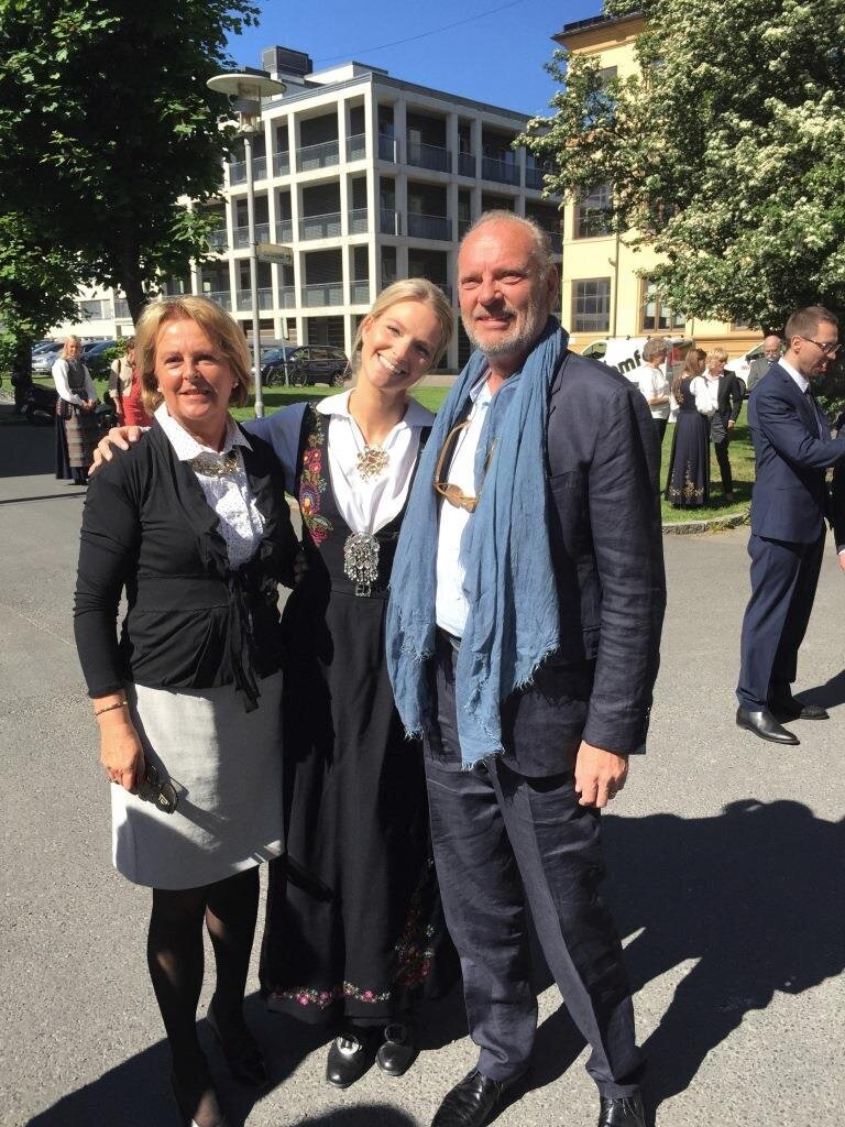 Bildet viser Frøya Marie Vinjar Eid i bunad mellom foreldrene Eli og Arve. Det er tatt dagen da hun fikk sin sykepleierautorisasjon.