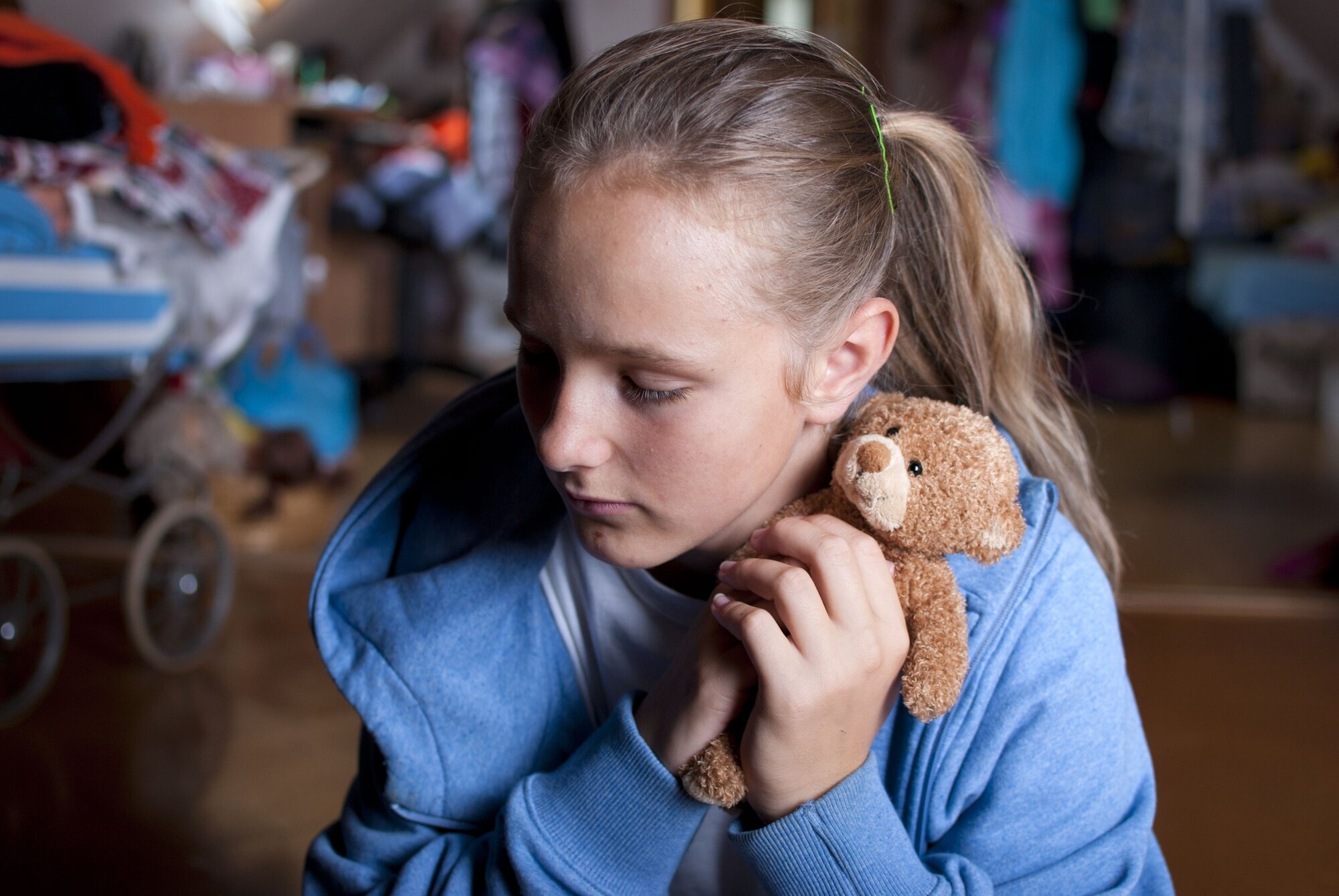 Trist jente holder rundt bamsen sin.