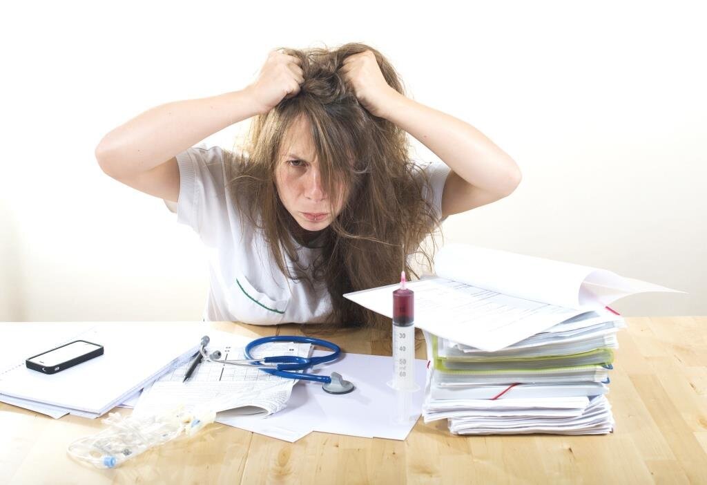 Bildet viser en frustrert sykepleier som river seg i håret.