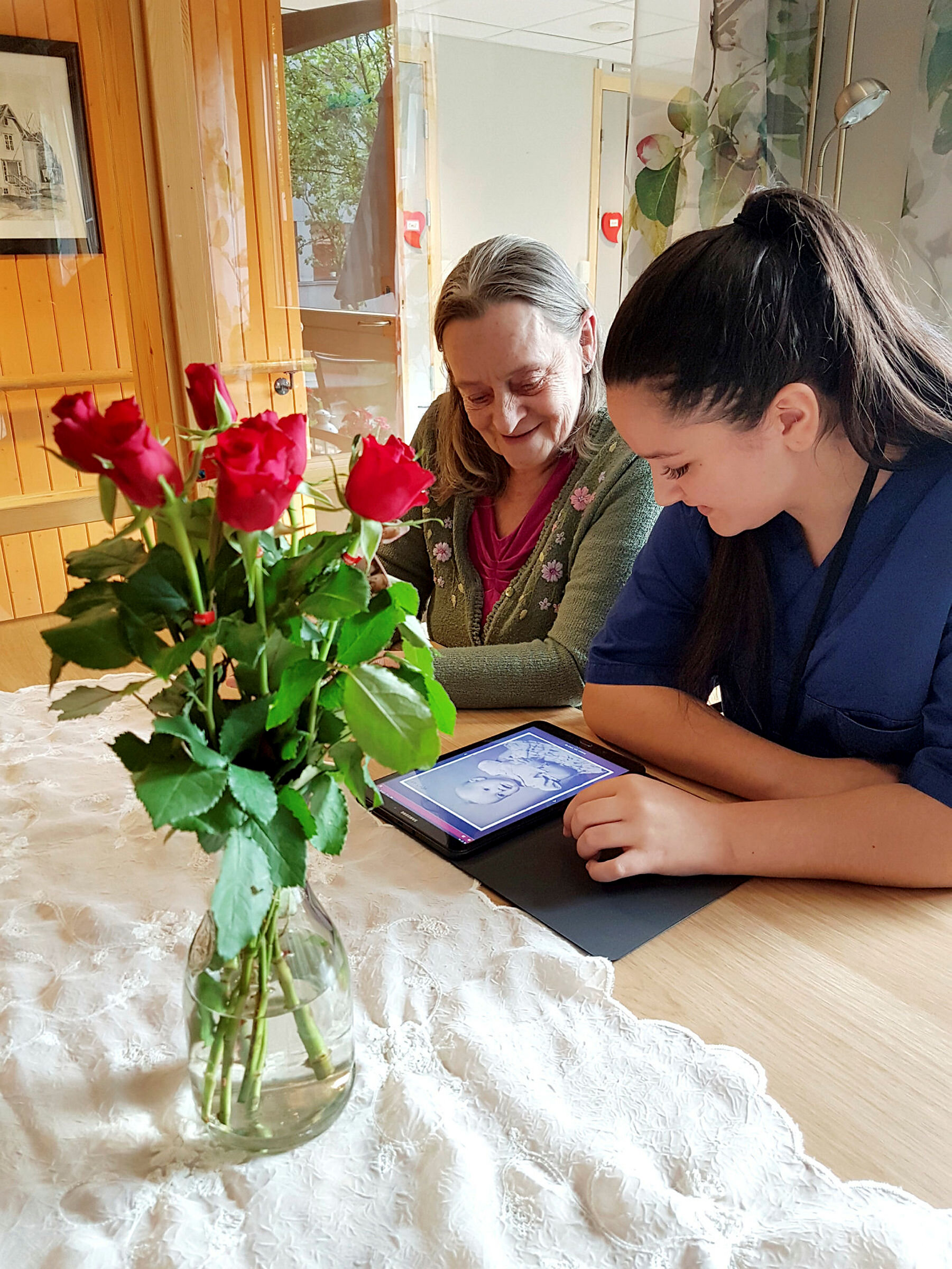 Lærling Tina Singh ser på bilder i appen Min Memoria sammen med beboer Kirsten ved Tiller helse- og velferdssenter i Trondheim 